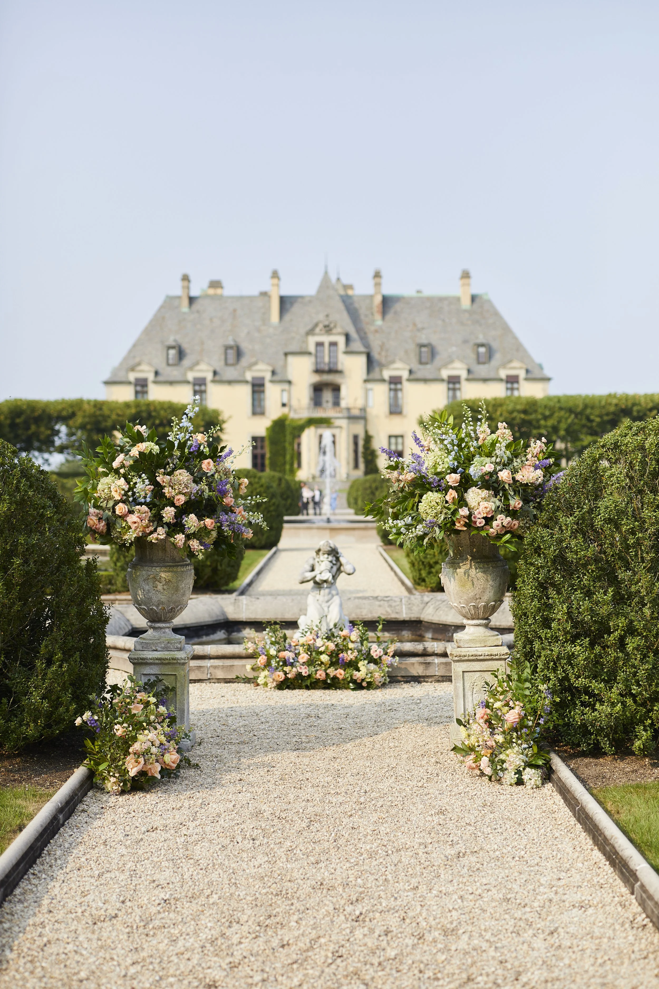 Garden ceremony aisle at Oheka Castle with lush floral arrangements and estate views