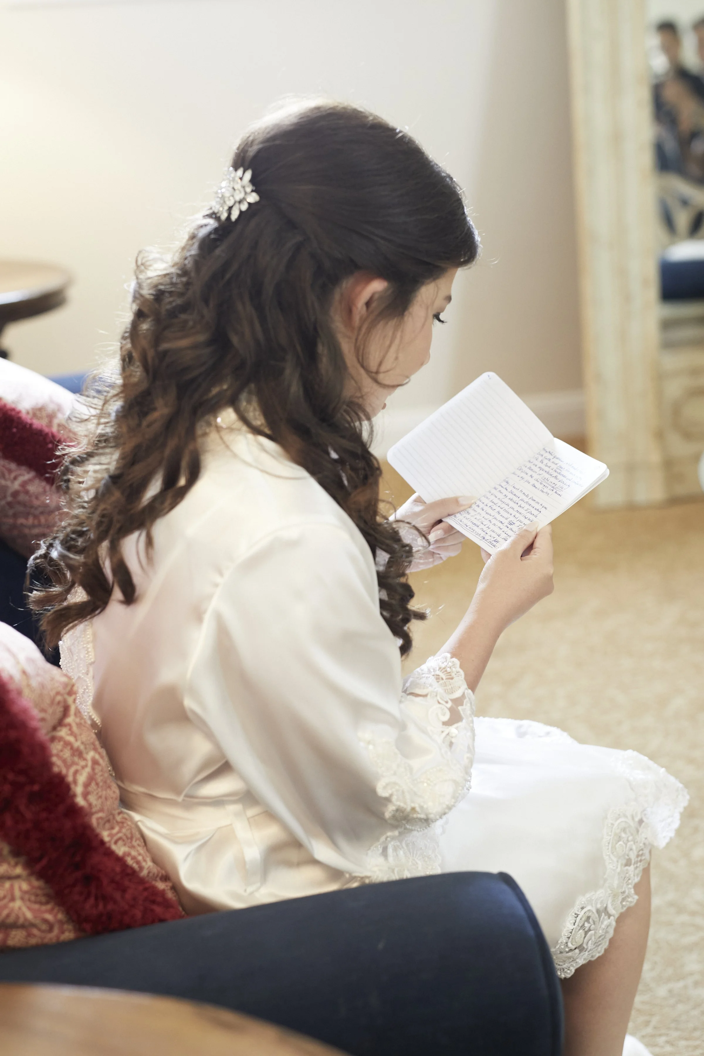 Samantha reading a heartfelt handwritten note from the groom Anthony during quiet moments of bridal preparations before the ceremony.
