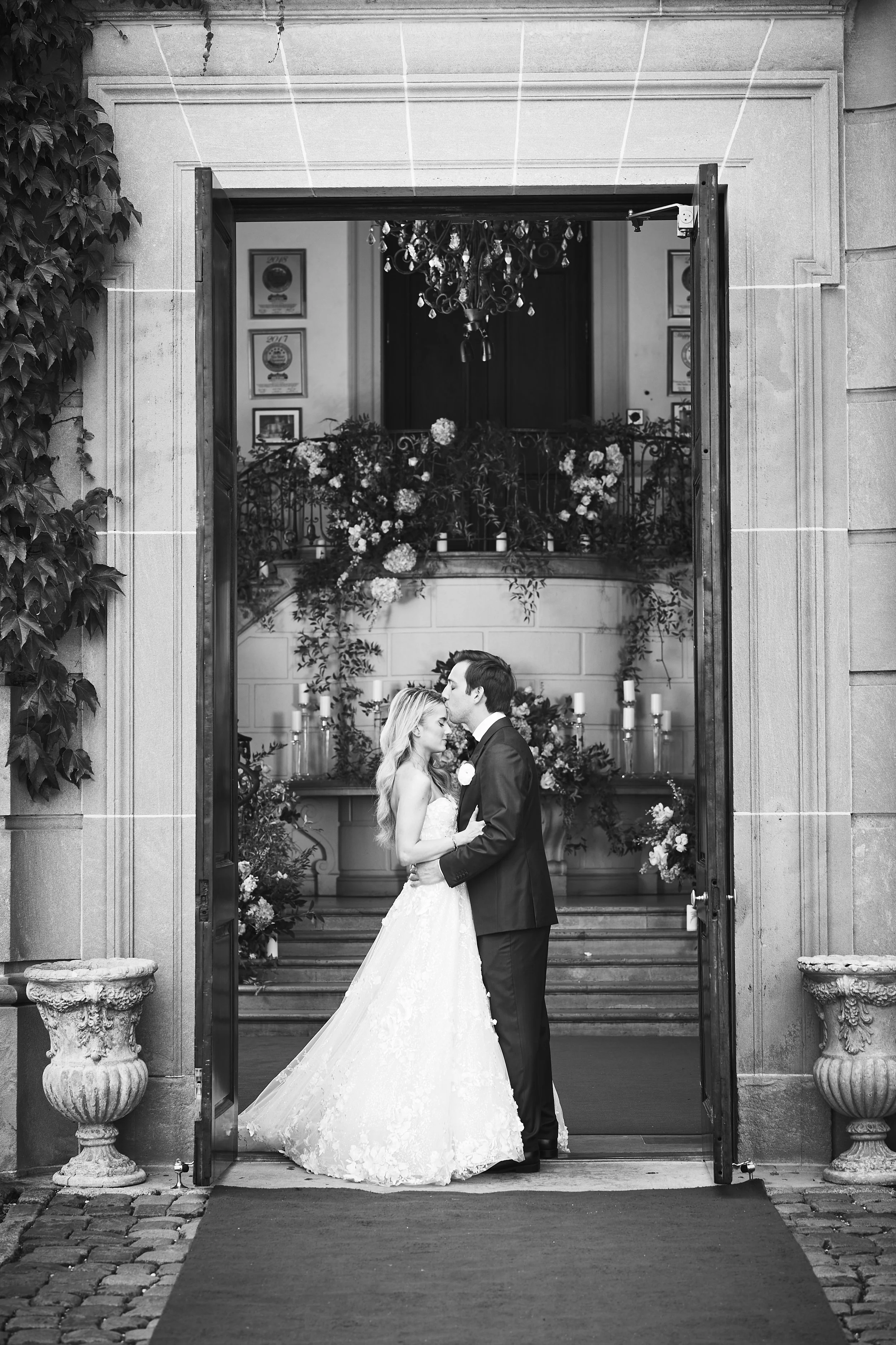 Bride and groom sharing a quiet moment in a doorway framed by floral décor