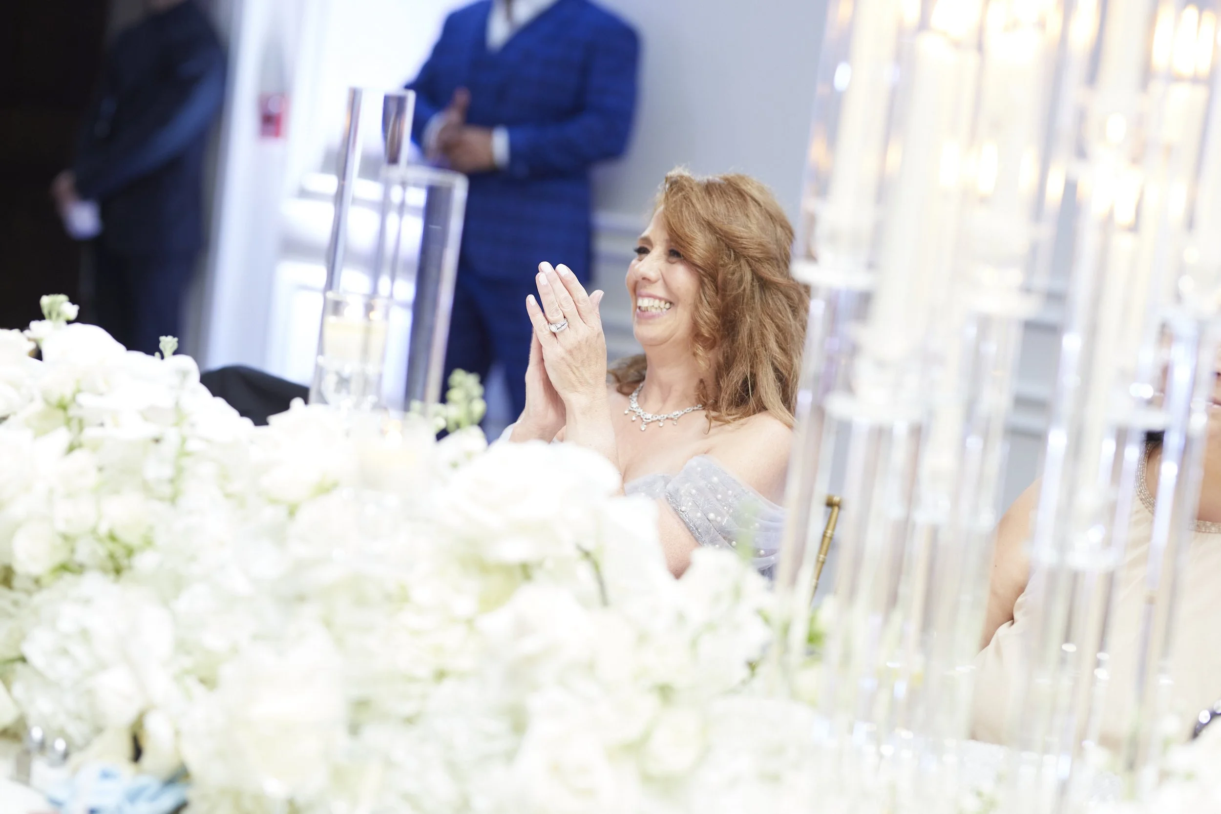 The mother of the bride applauding at her daughters wedding.