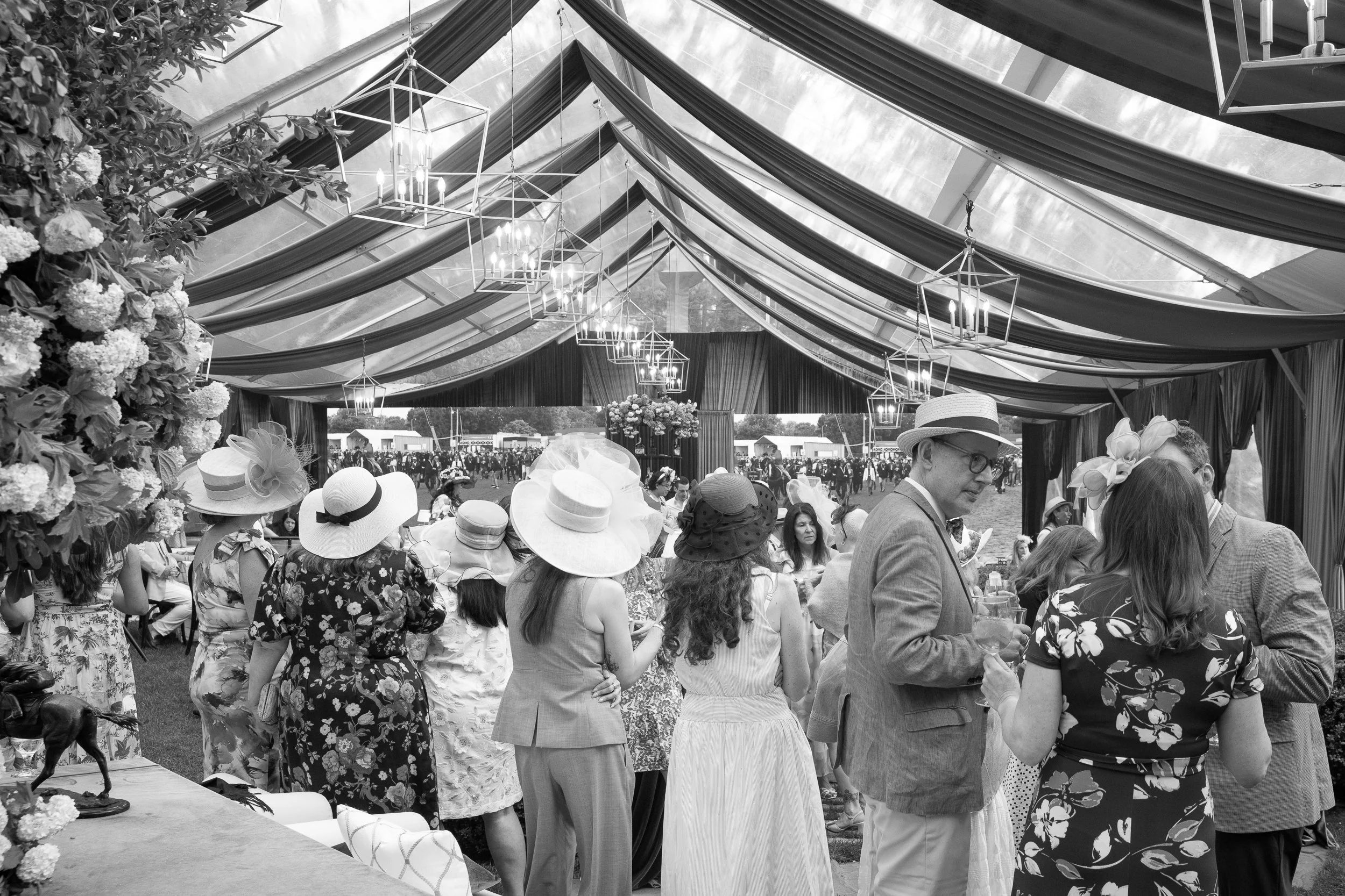 Black-and-white moments captured the timeless social energy and celebratory atmosphere of the tented Derby gathering as guests watched the race live on large LED screens.