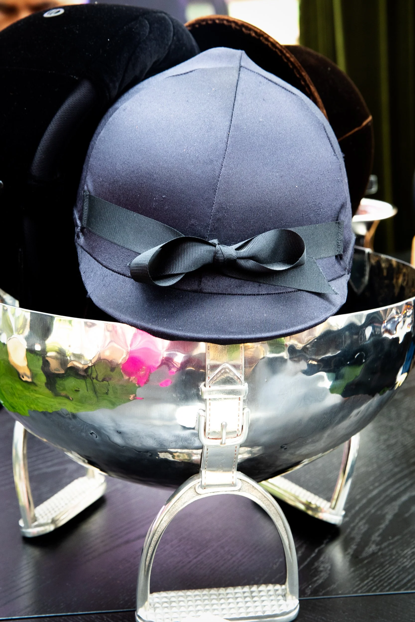 Equestrian-inspired styling moments featuring custom riding helmets and polished silver details layered throughout the event décor.