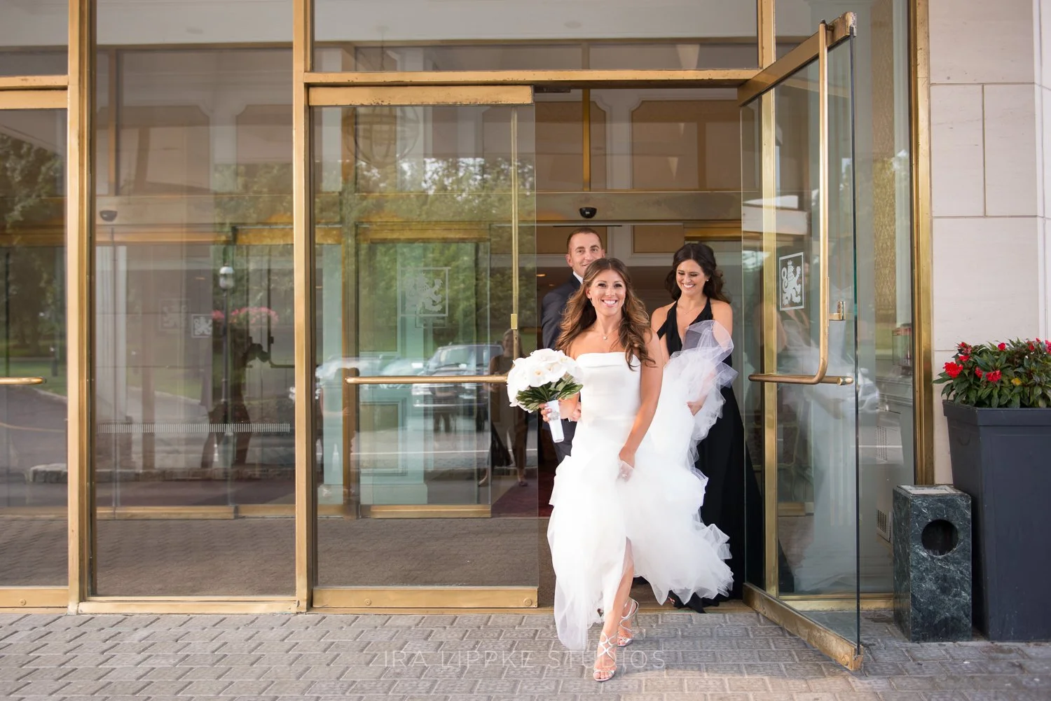 The bride and her mother share a celebratory moment as they leave the hotel, ready to make their way to the ceremony.