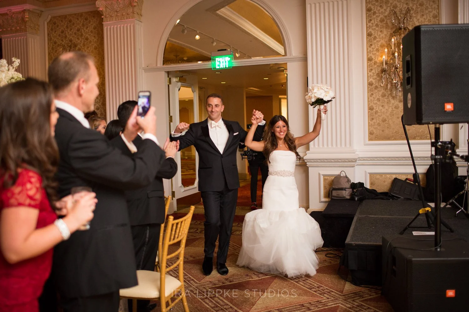 The newlyweds are enthusiastically welcomed into the ballroom as they make their grand entrance to begin the reception festivities.