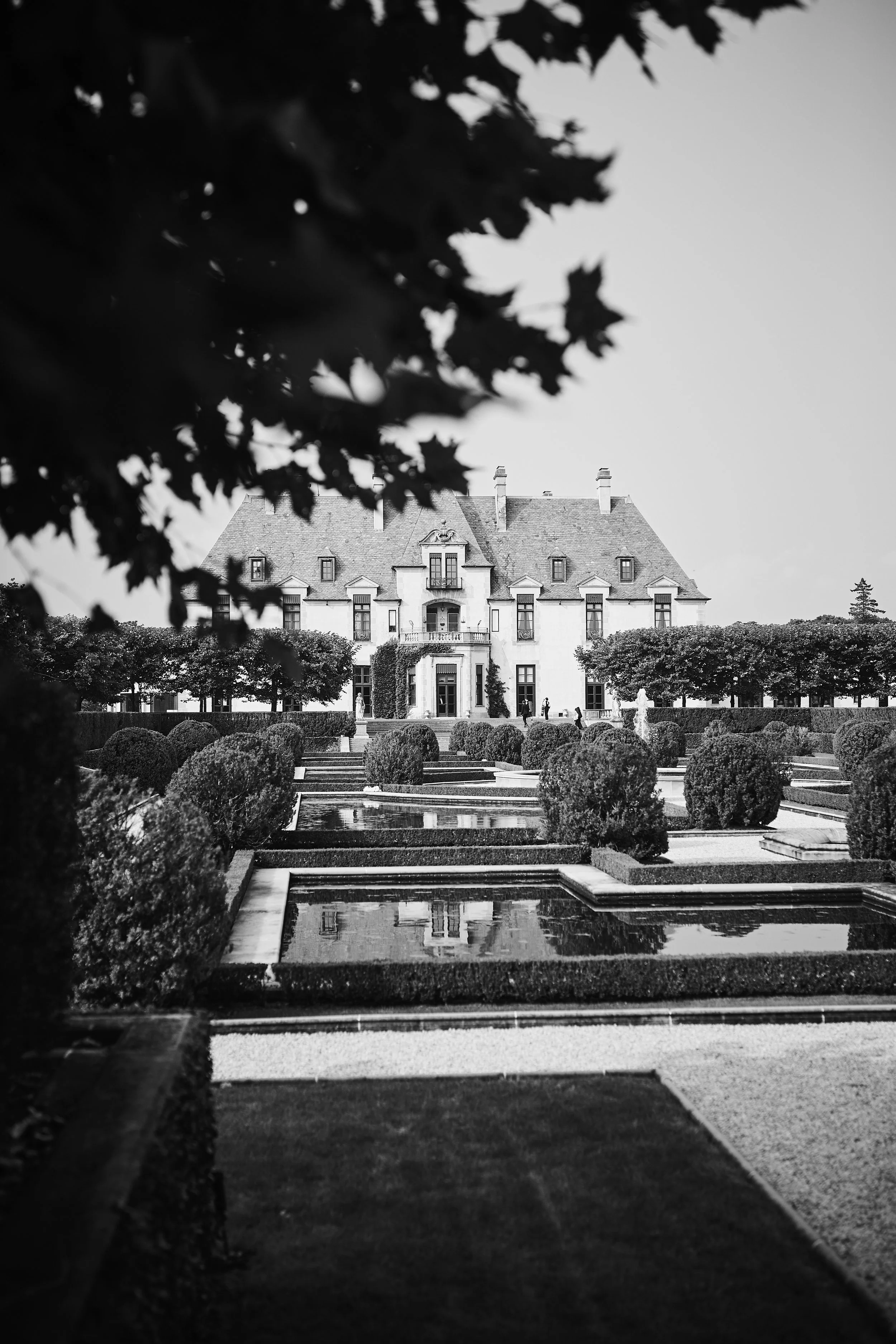 Elegant black and white view of Oheka Castle overlooking the formal water gardens on Long Island