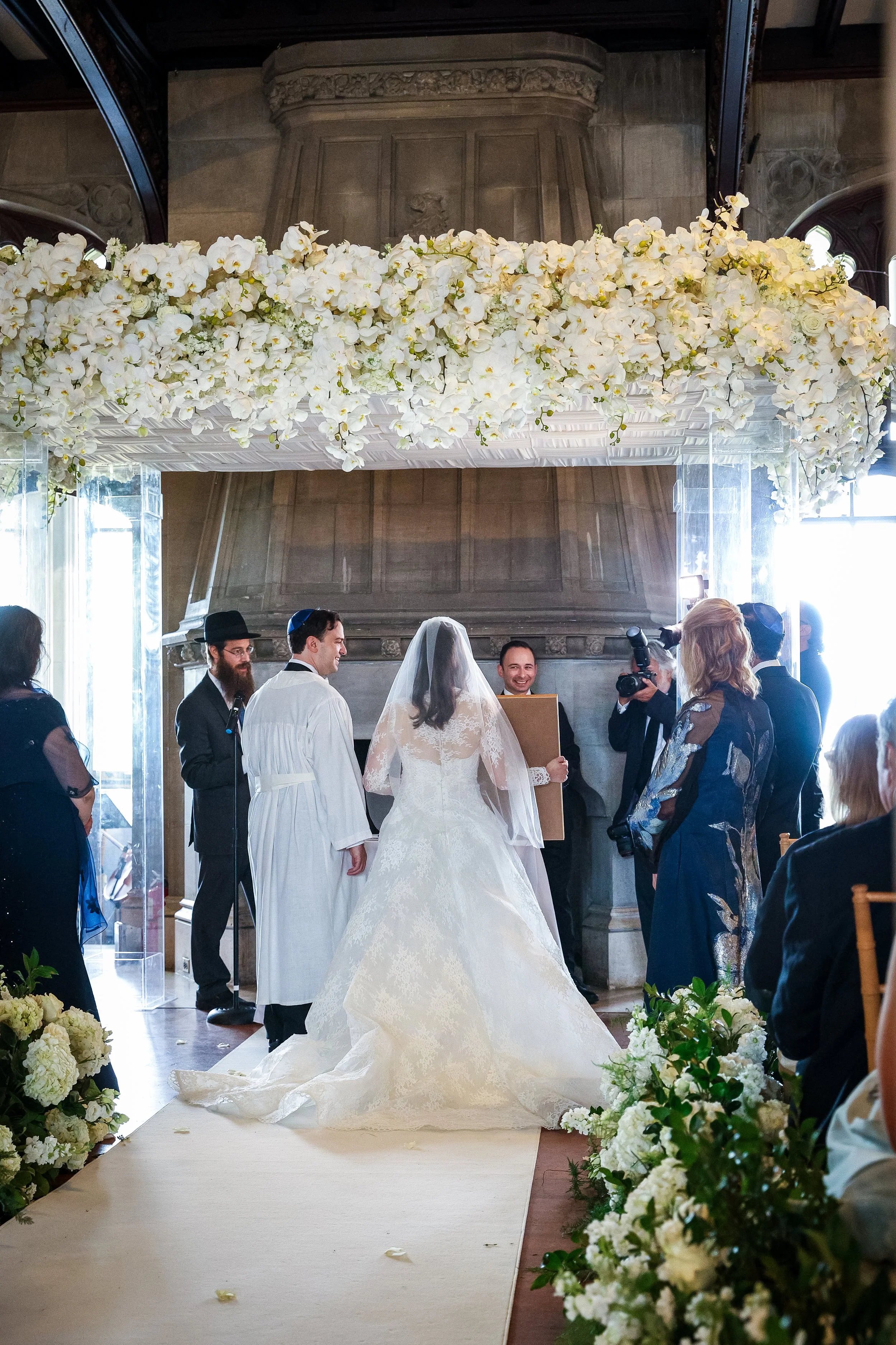 Jewish wedding ceremony at Hempstead House with floral chuppah and aisle lined with white flowers