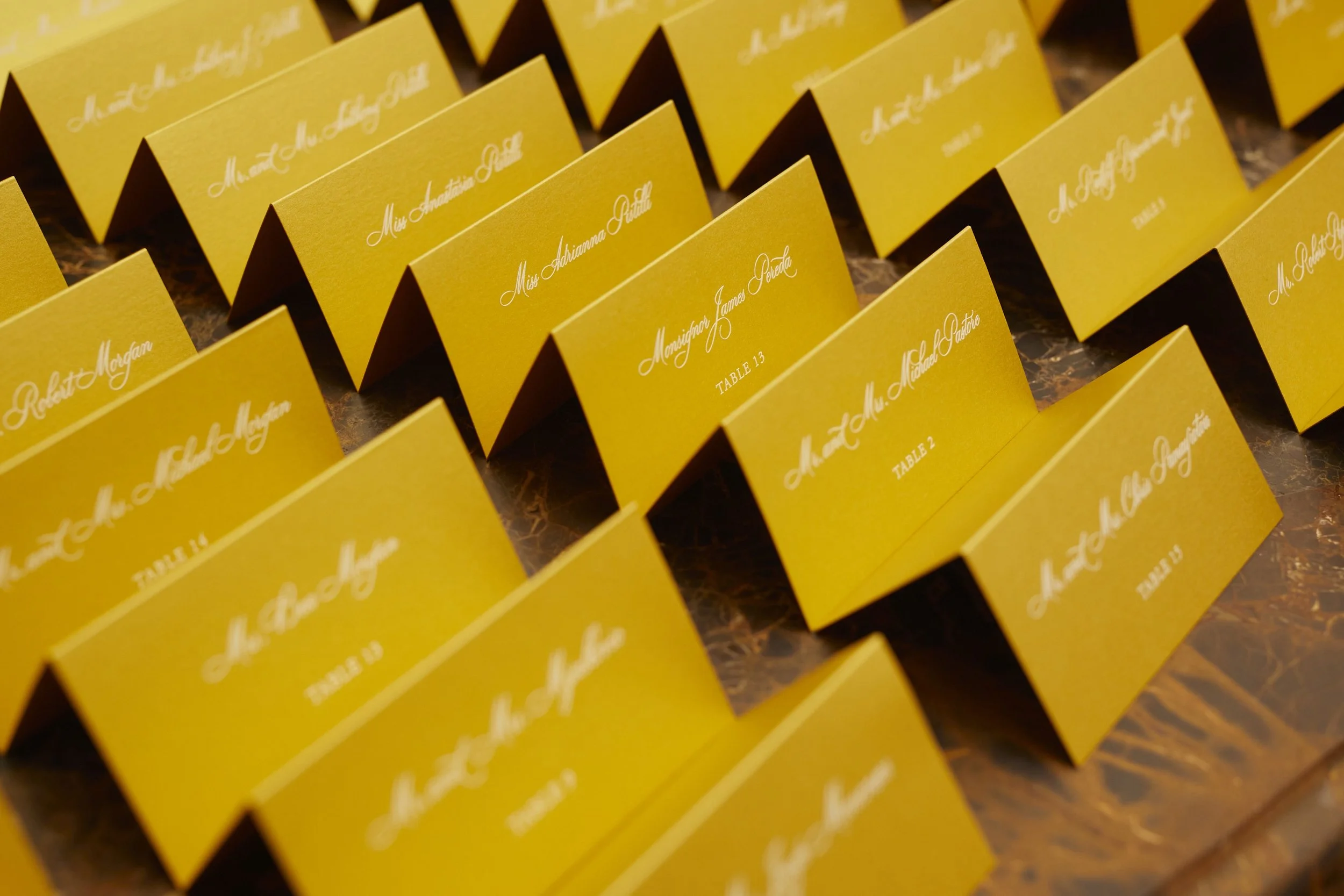 Gold escort cards featuring white text assembled for guest arrival.