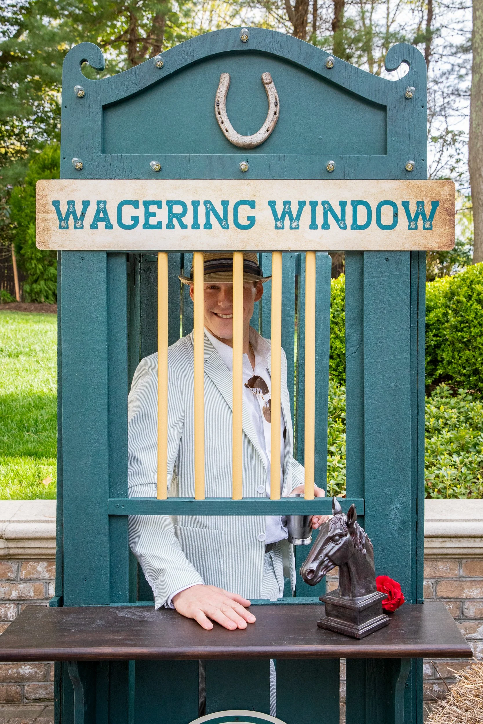 A custom-built wagering window installation created an authentic race-day atmosphere beneath the tented celebration.