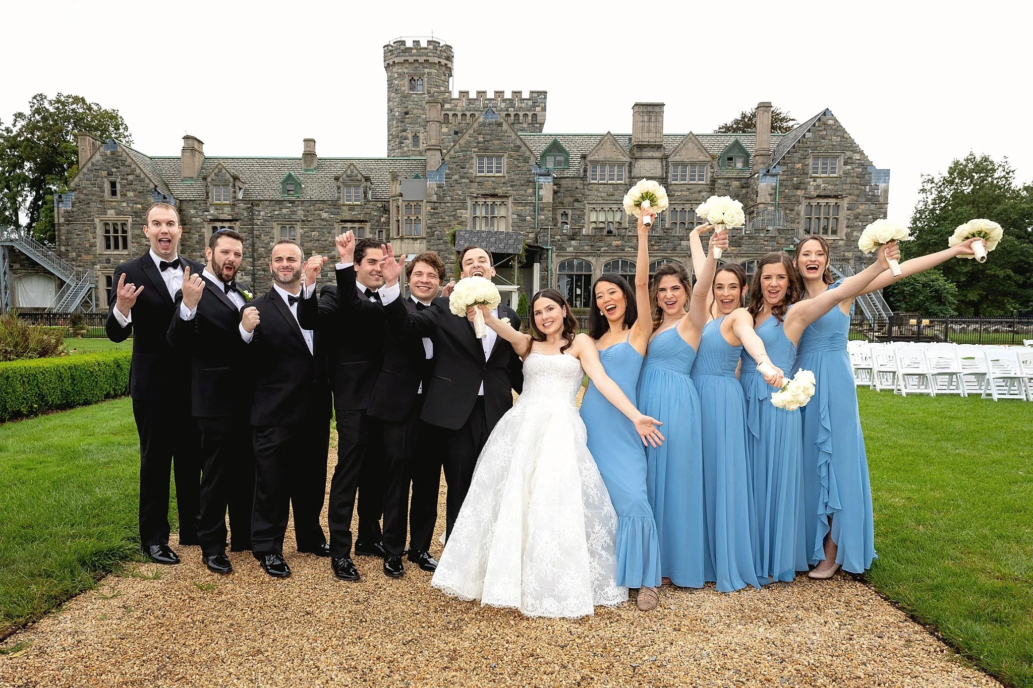 Bridal party celebrating in front of Hempstead House at Sands Point Preserve wedding