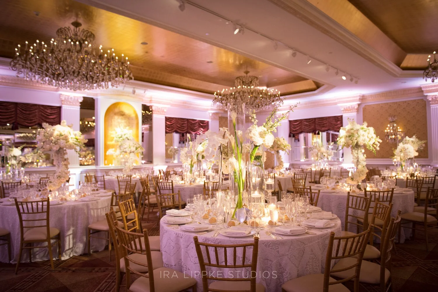 A wide view of the reception space showcases the sophisticated design, glowing candlelight, and inviting atmosphere created for guests.
