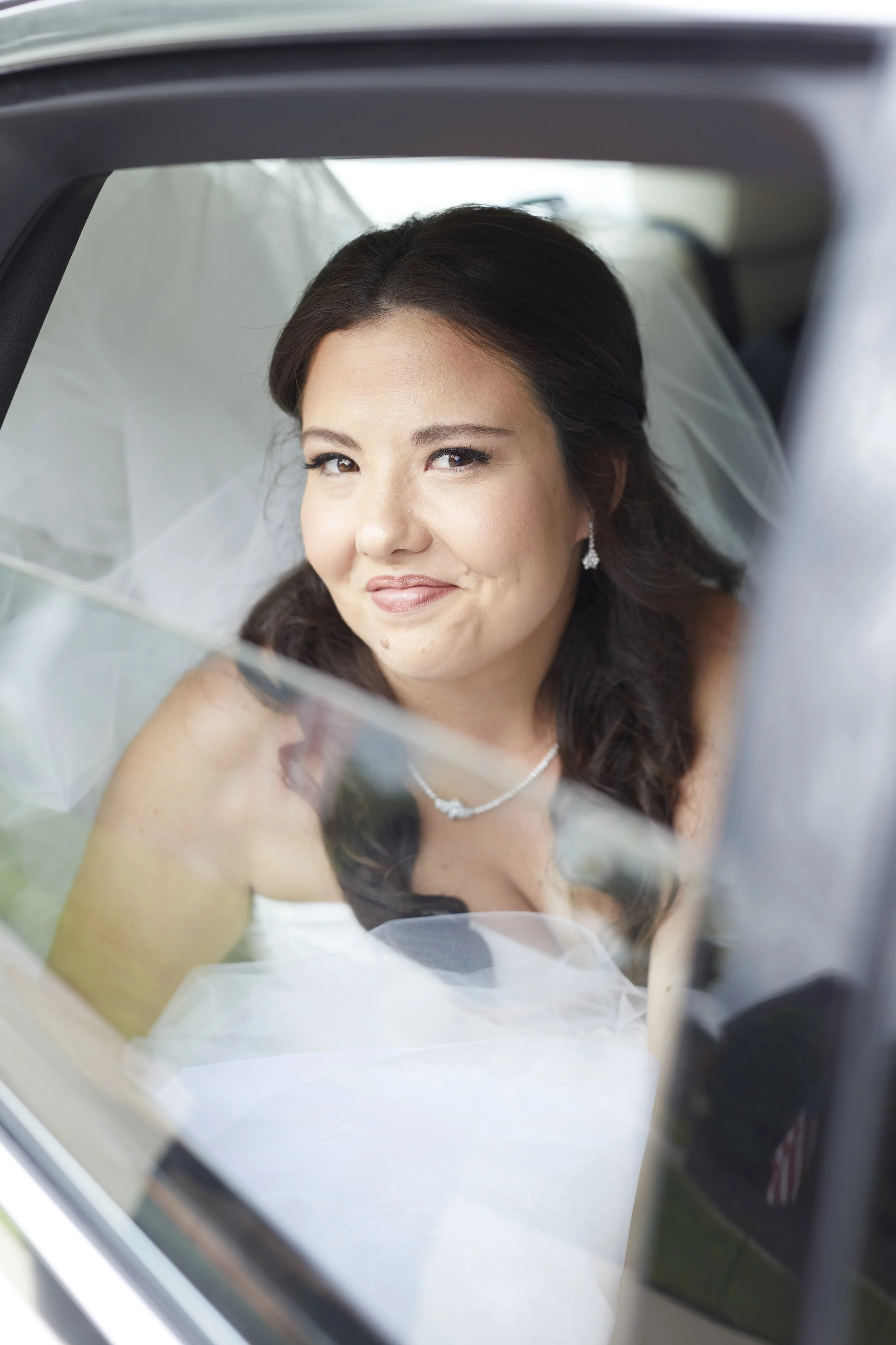 Bride portrait looking out the window of the limousine as she departs for church.