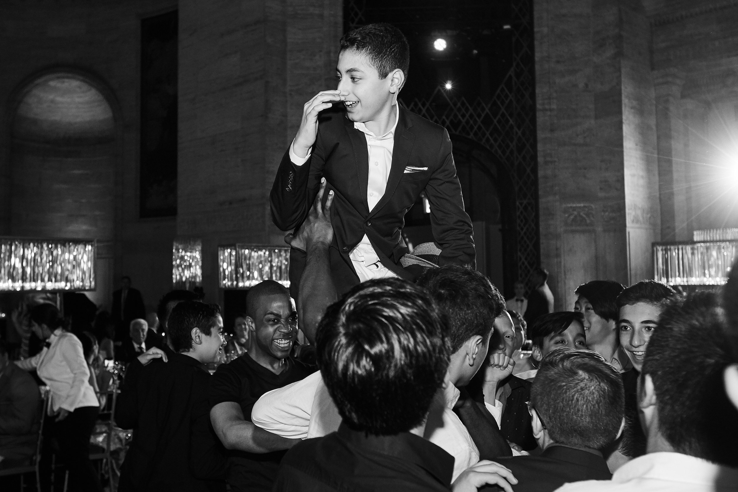 Bar Mitzvah hora dance at Cipriani Wall Street in New York City — Skyler lifted high above the crowd as the energy builds, capturing the joy, tradition, and excitement of the celebration in full motion.