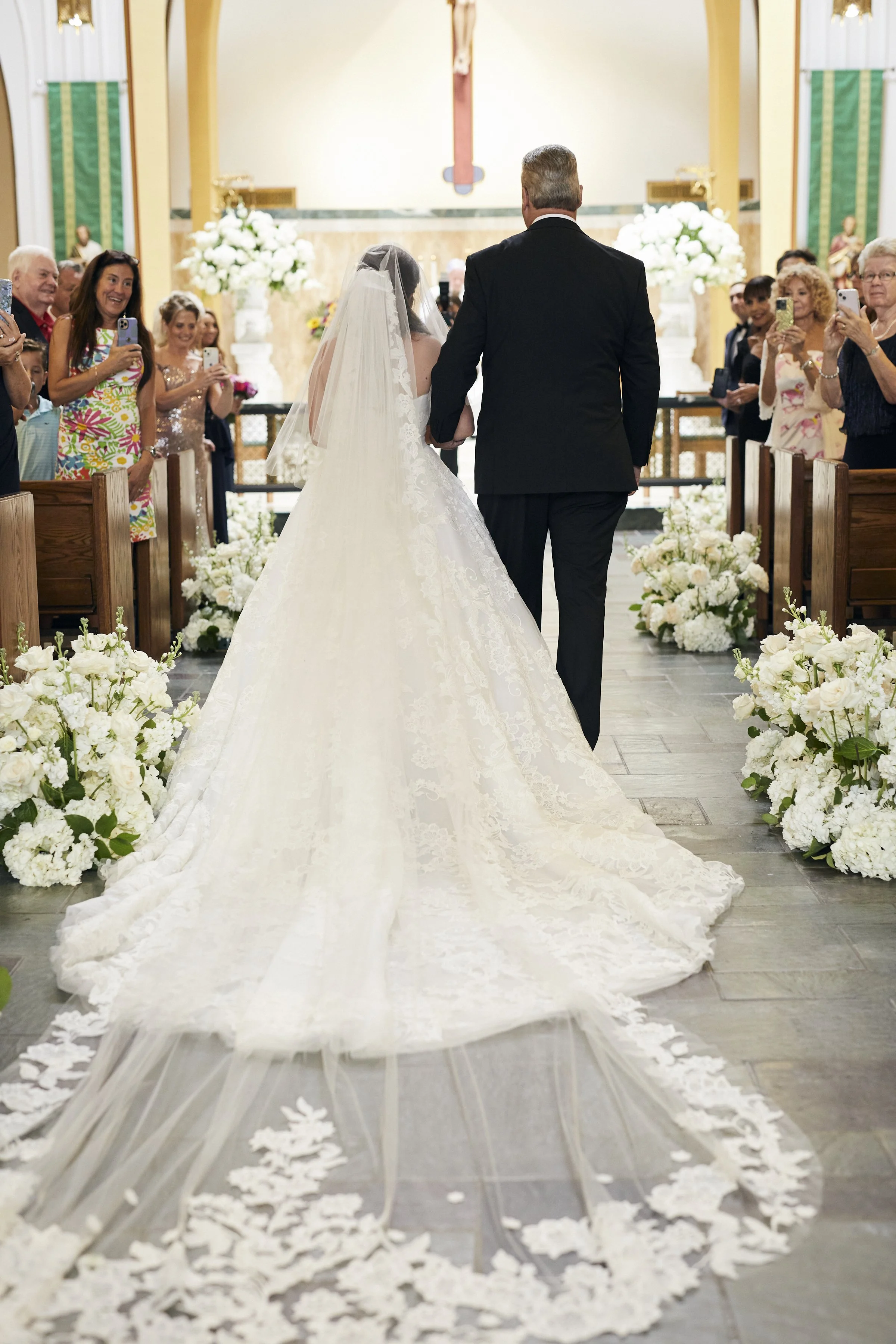 Bride escorted by her father approaching the alter at her wedding ceremony.
