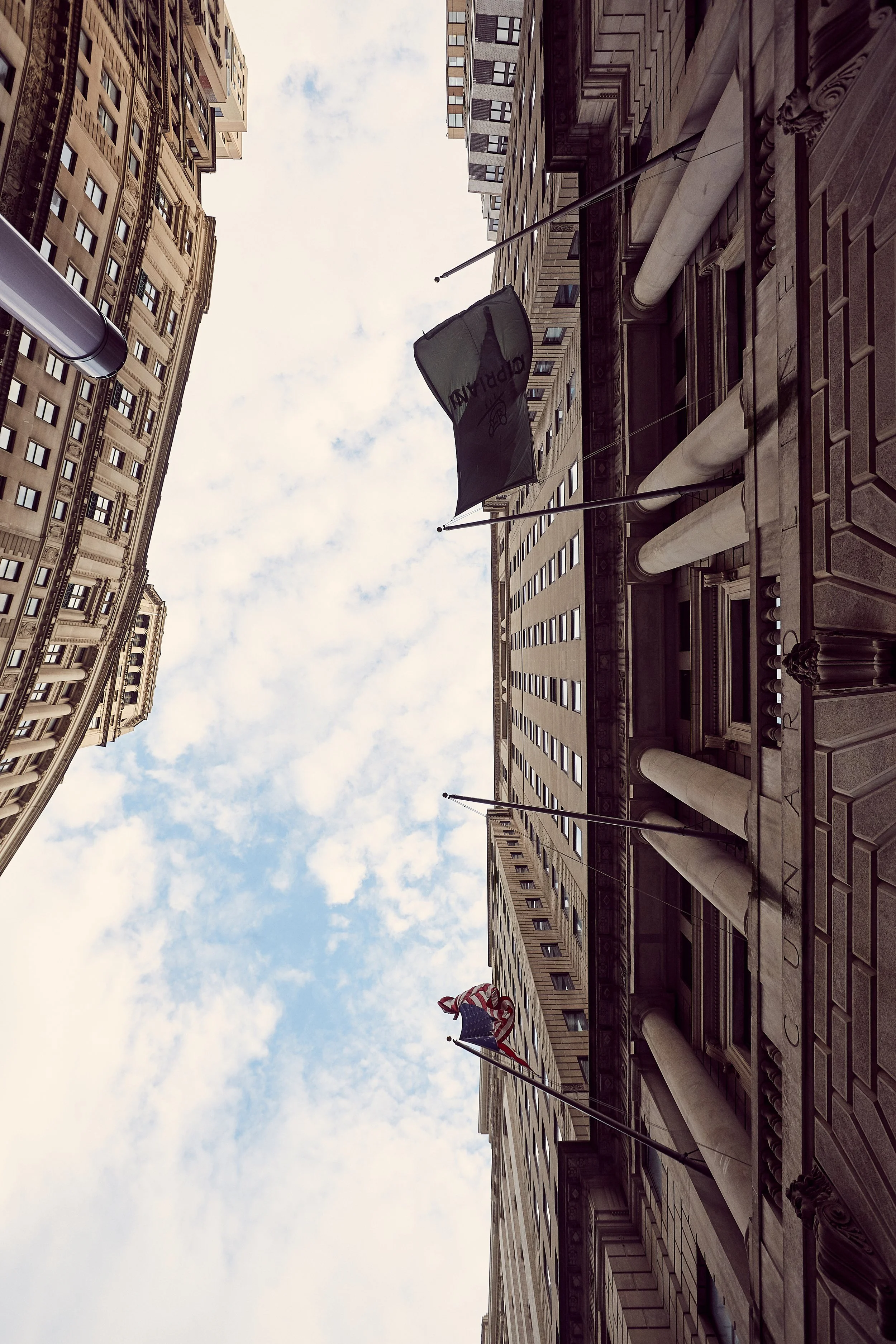 Cipriani Wall Street exterior architecture in New York City — a dramatic upward perspective capturing the grandeur of historic columns and the scale of downtown Manhattan’s iconic streetscape.