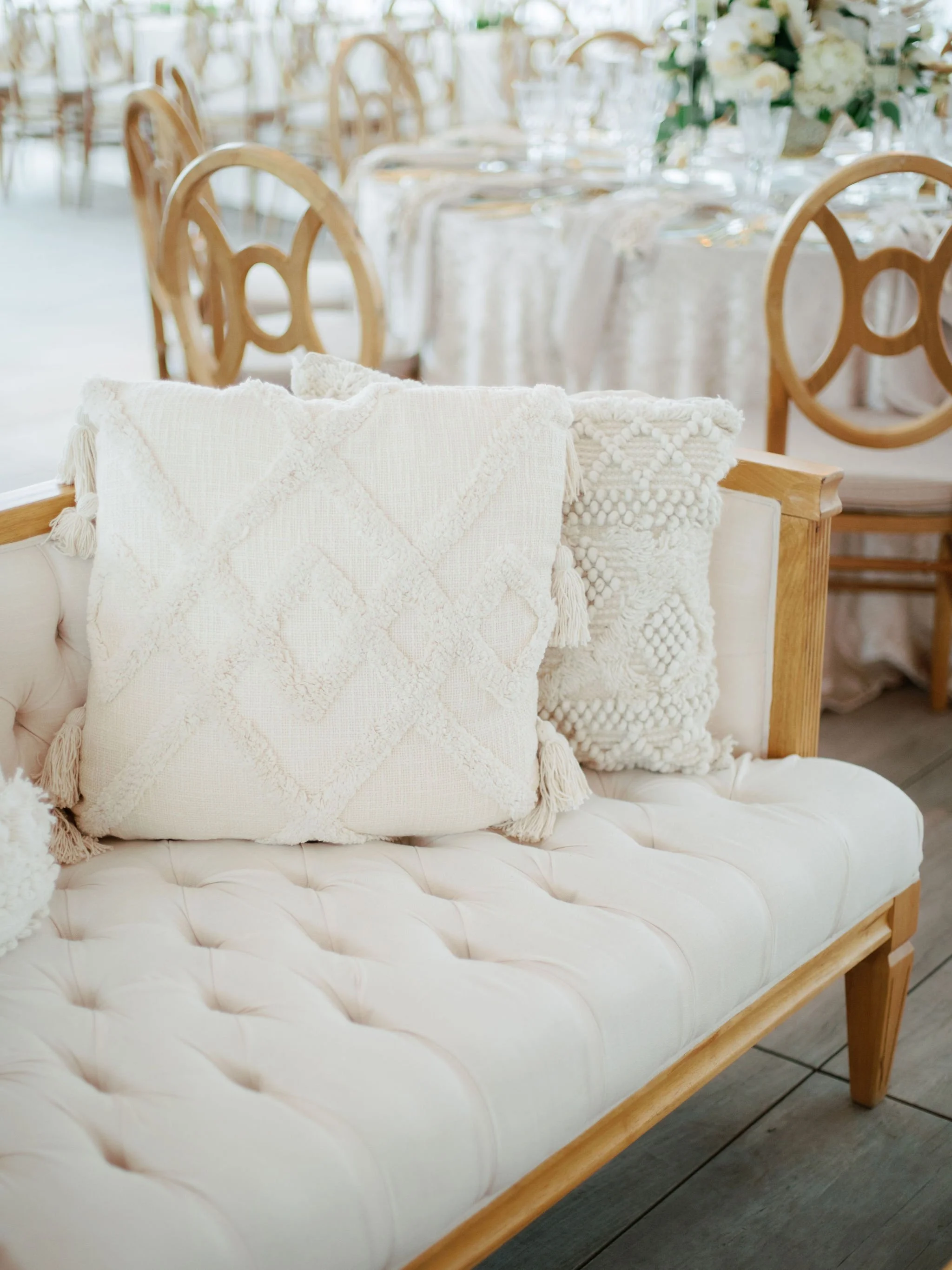 A softly layered lounge invited guests to relax and linger, where textured linens, carved wood, and warm metallic accents came together in a palette that felt effortlessly coastal and refined.