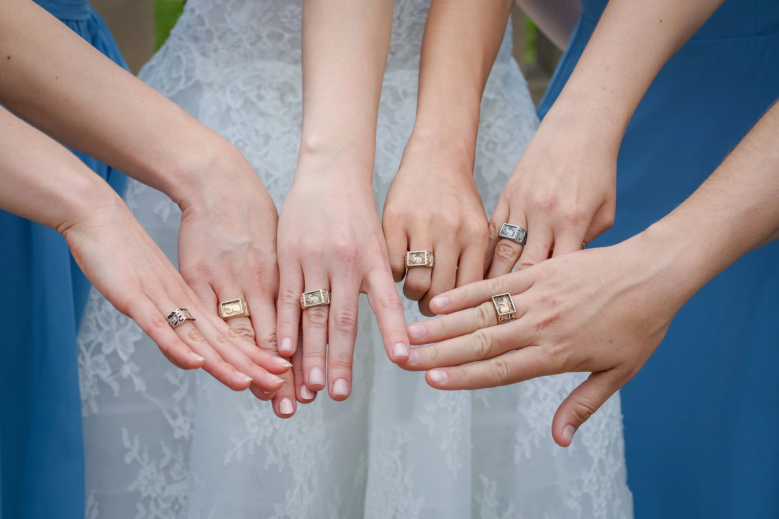 Bridesmaids showing sorority rings with bride in blue dresses at Hempstead House wedding