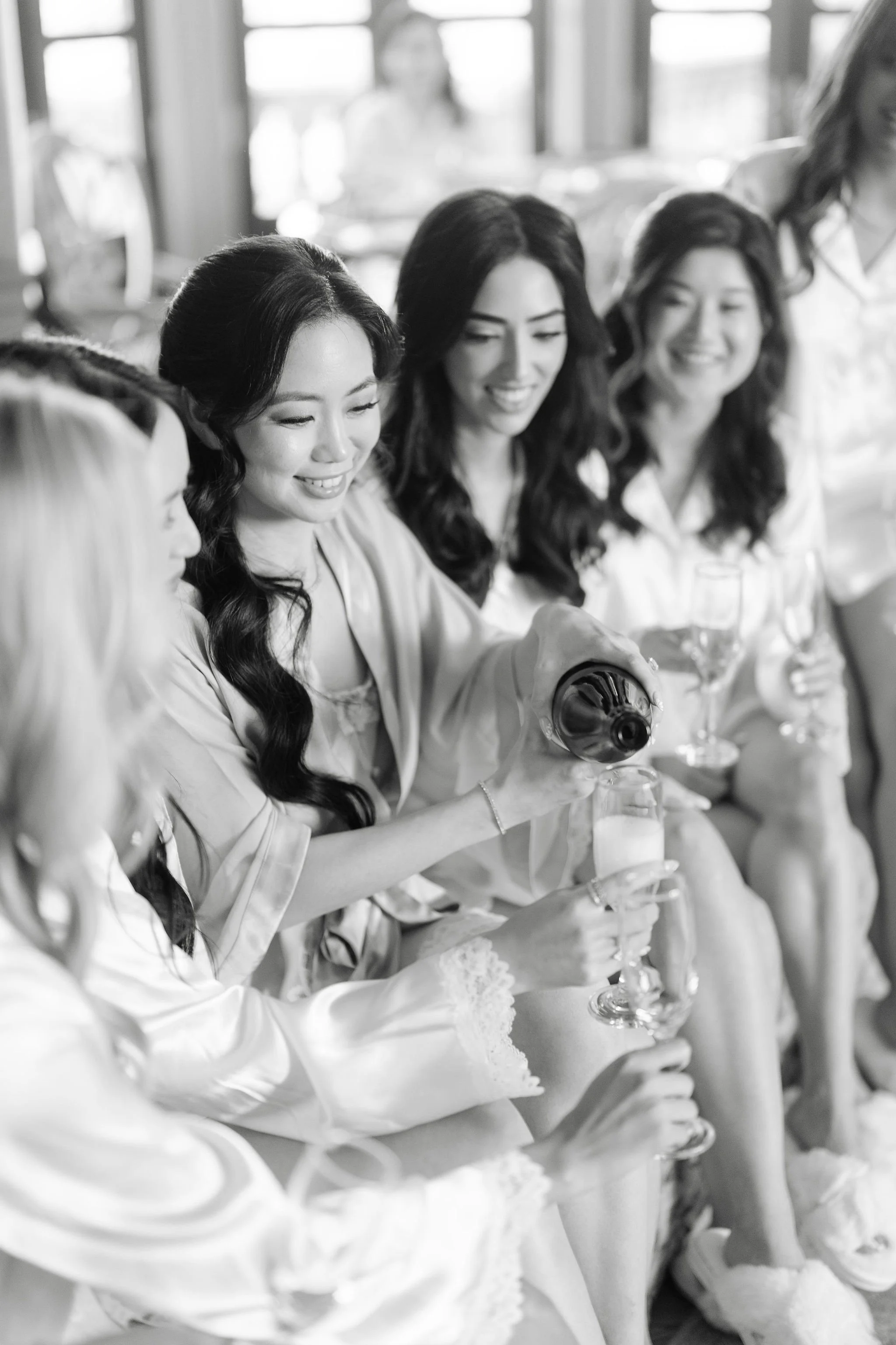 Group of women dressed in robes enjoying drinks at a social gathering.