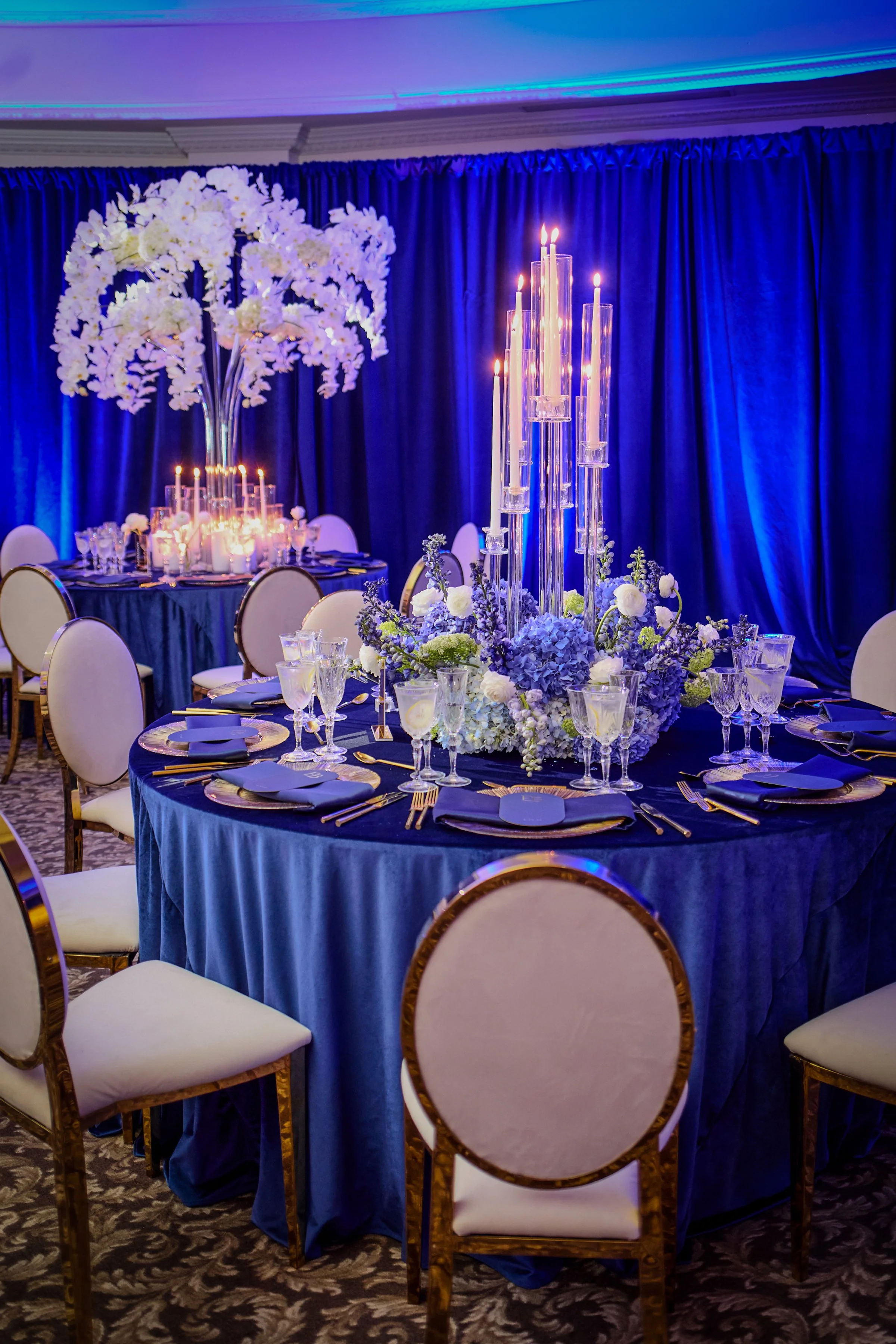 The Terrace Room was enveloped in rich shades of blue, layered with soft candlelight, abundant florals, and tailored details that created a warm, immersive atmosphere. Each table felt thoughtfully composed, contributing to a space that was both intim