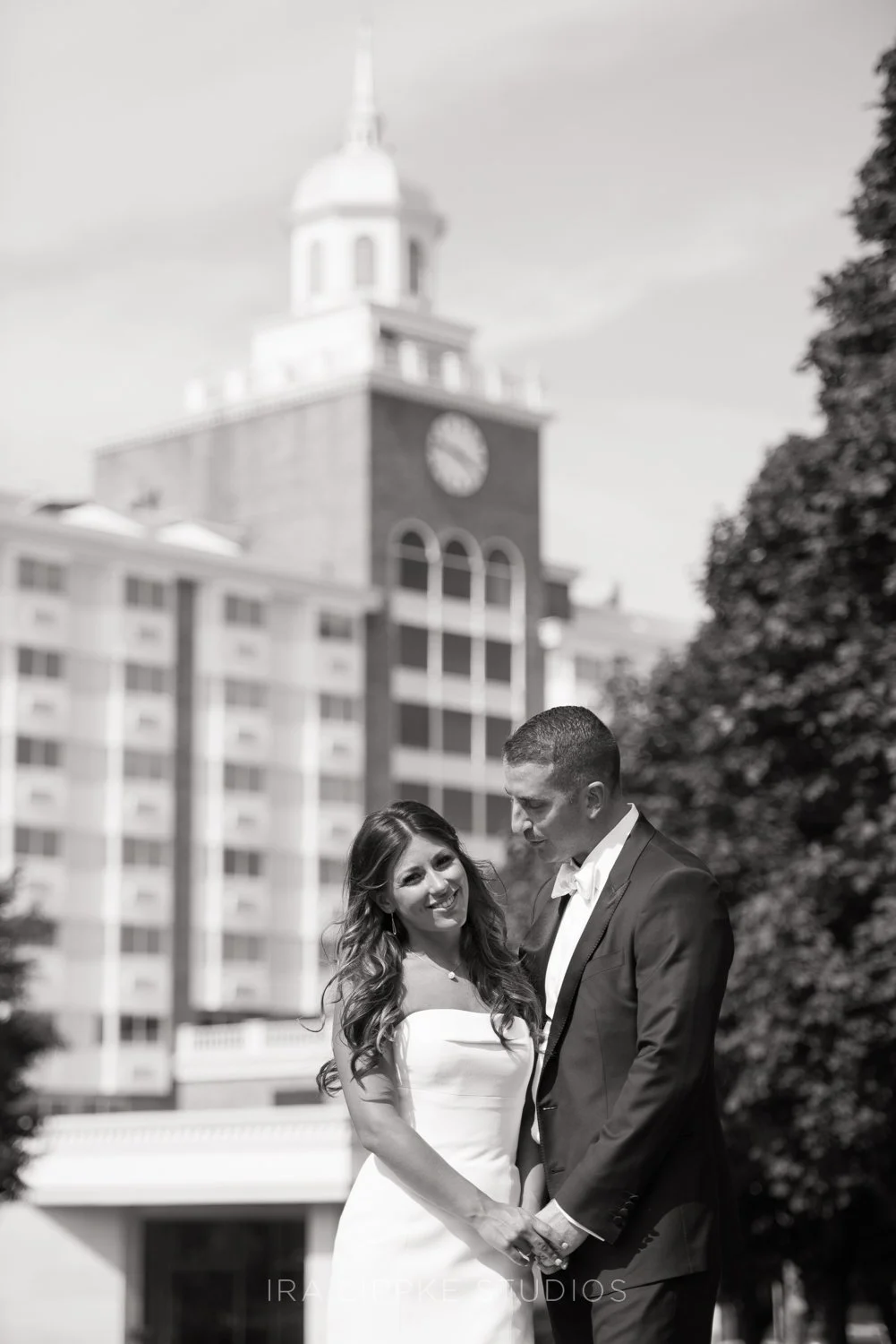 The couple pauses for portraits with the historic Garden City skyline in the background, capturing the excitement and emotion of the day.