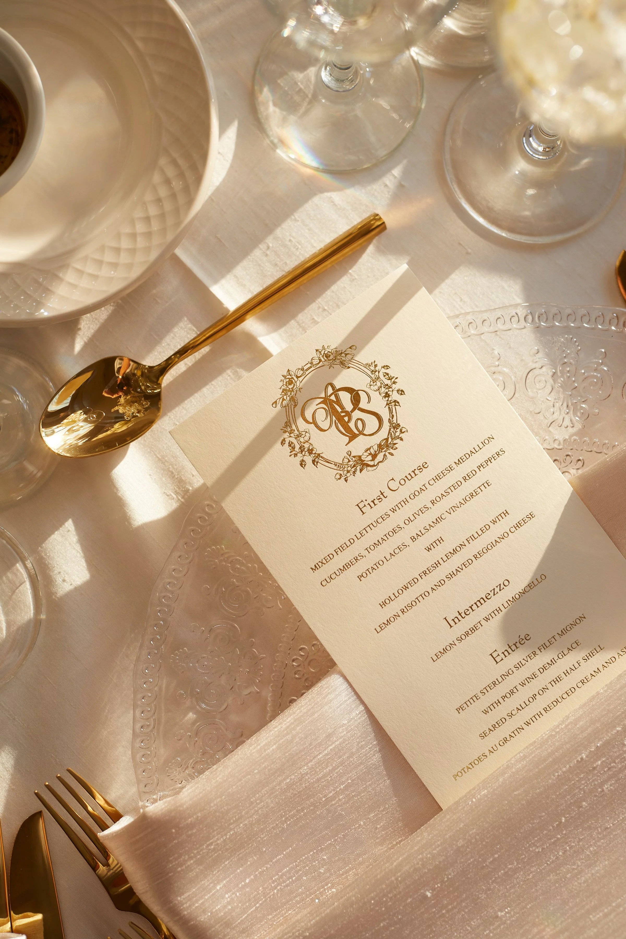 Samantha and Anthony’s custom wedding menu displayed alongside gold flatware and refined reception details during the candlelit dinner service.