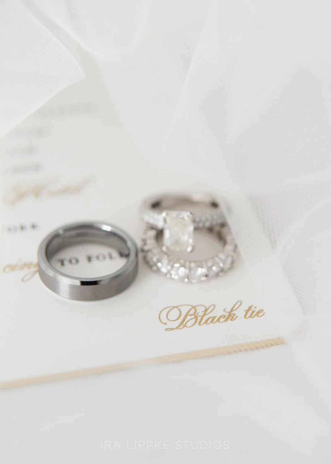 The couple’s wedding bands and engagement ring are elegantly displayed atop their invitation suite, capturing the timeless details that tell the story of the day.