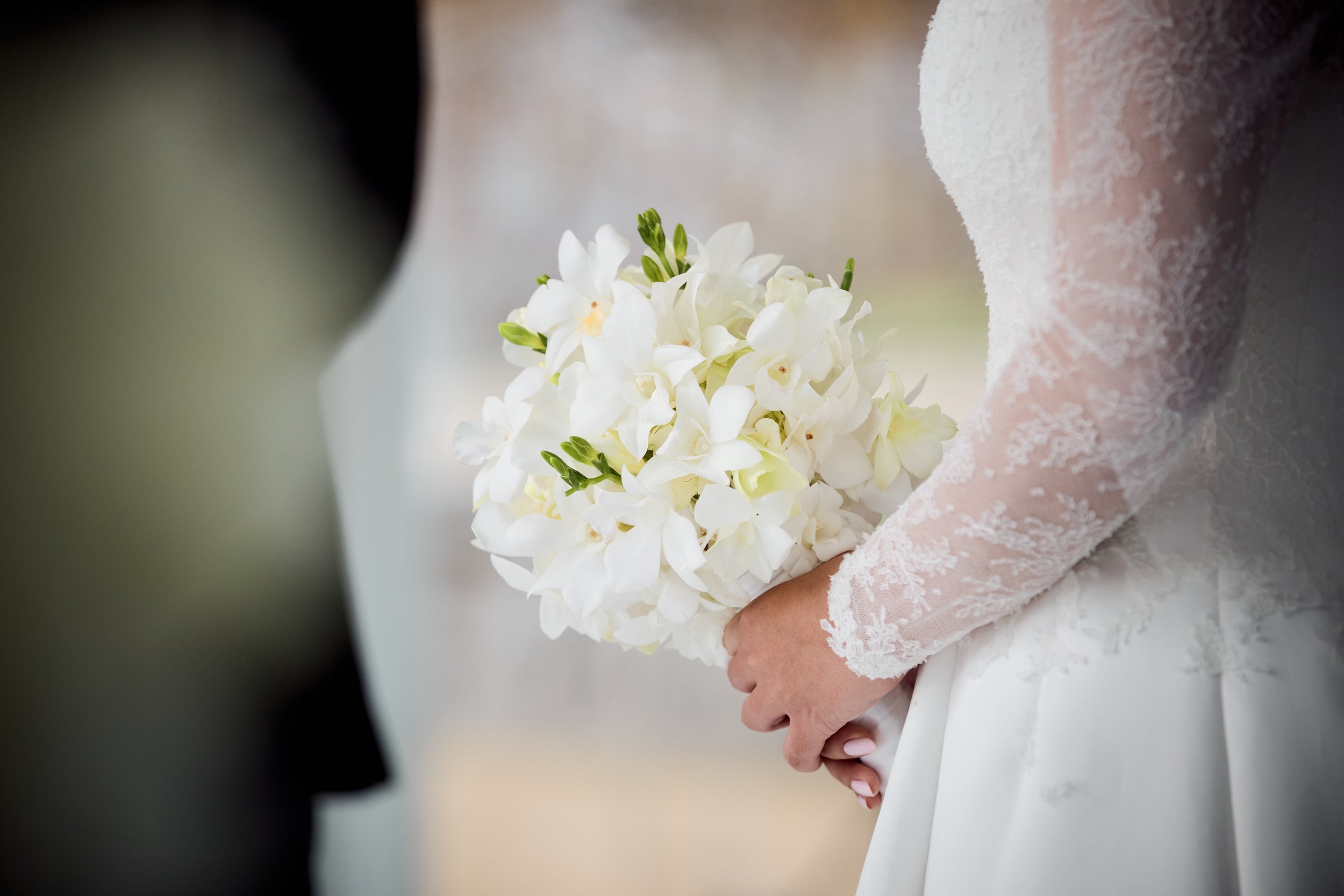 A soft, monochromatic bouquet designed to complement the bride’s look with understated elegance.
