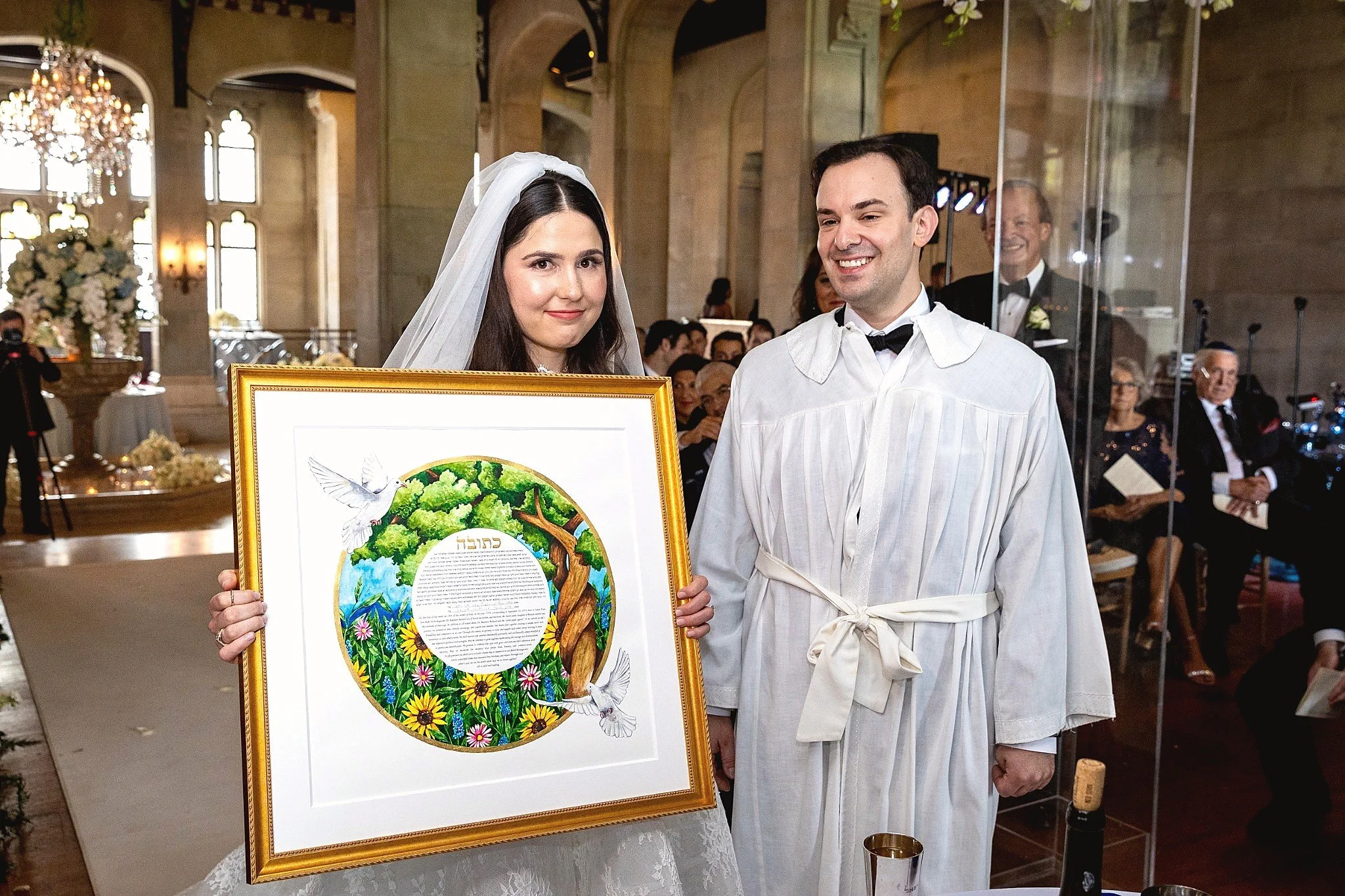 Bride and groom holding custom ketubah artwork during Jewish wedding ceremony at Hempstead House