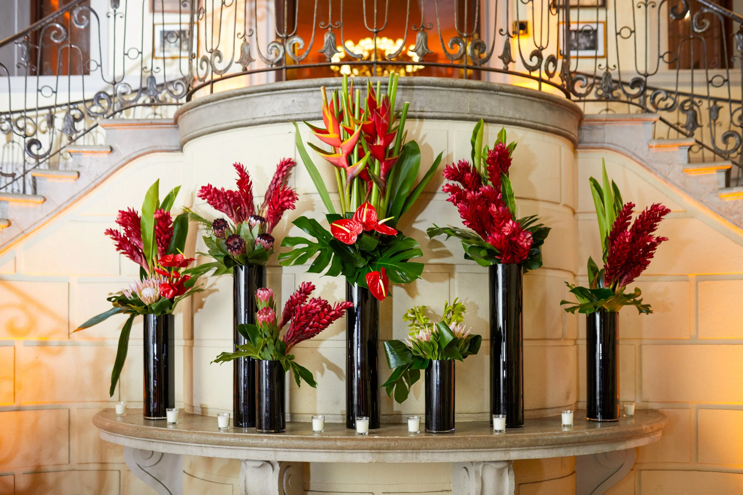 Tropical floral arrangements in black vessels