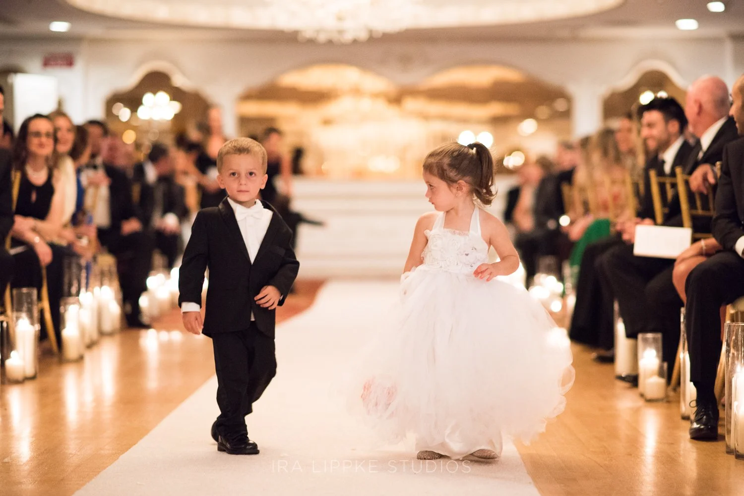 The flower girl and ring bearer make their way across the ballroom floor, delighting guests with their charm and confidence.