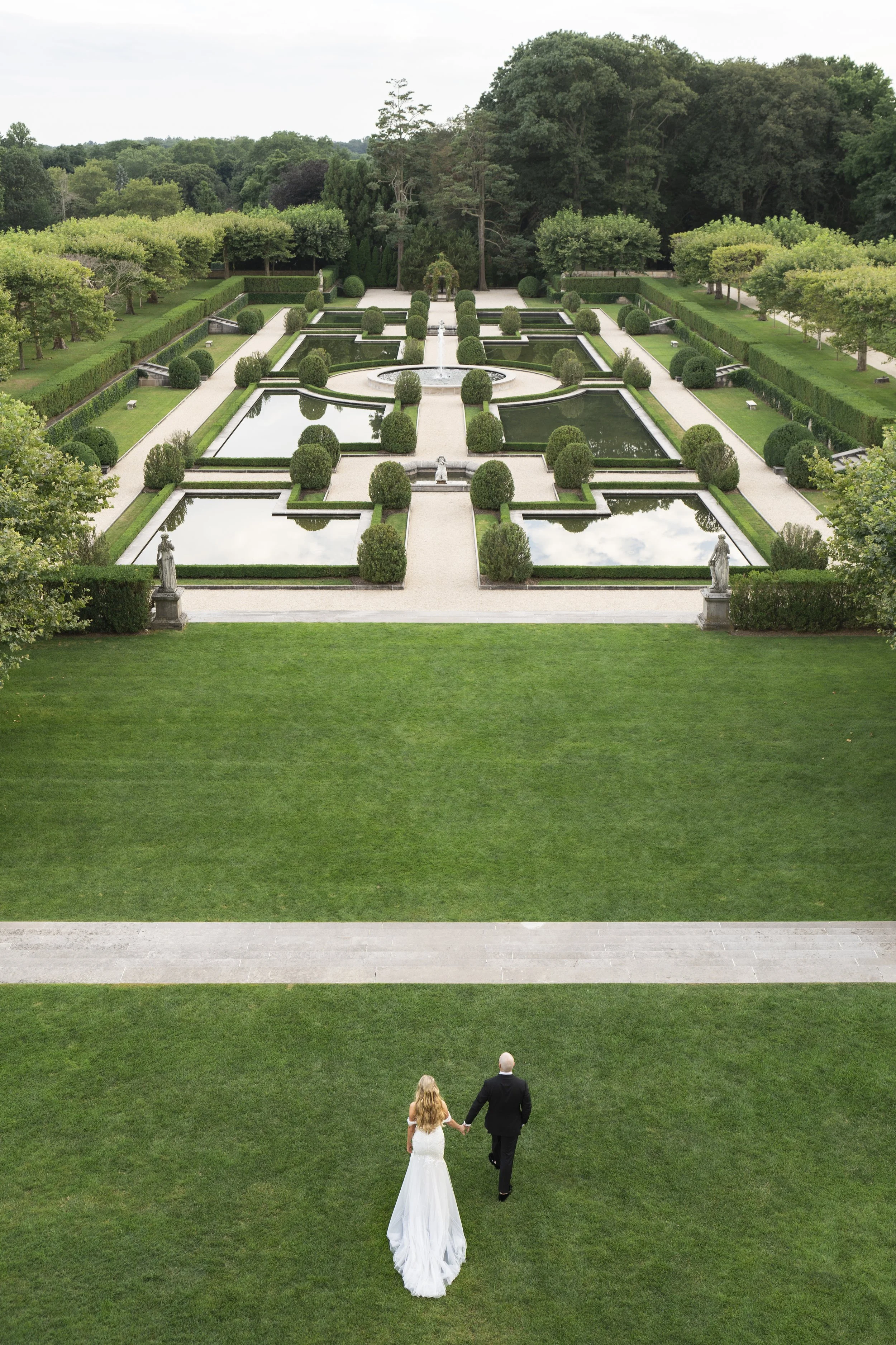 Aerial view of Oheka Castle formal gardens with couple walking through the grounds
