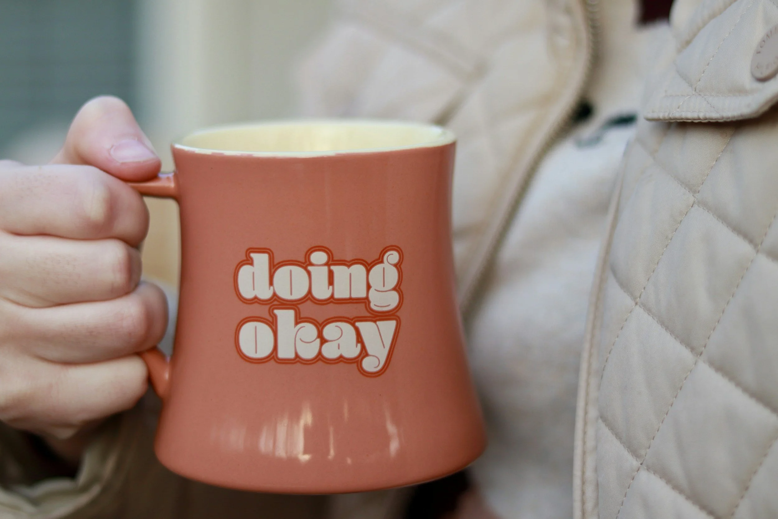 therapist holding a coffee cup that says "doing okay" after attending an EMDR confidence lab workshop
