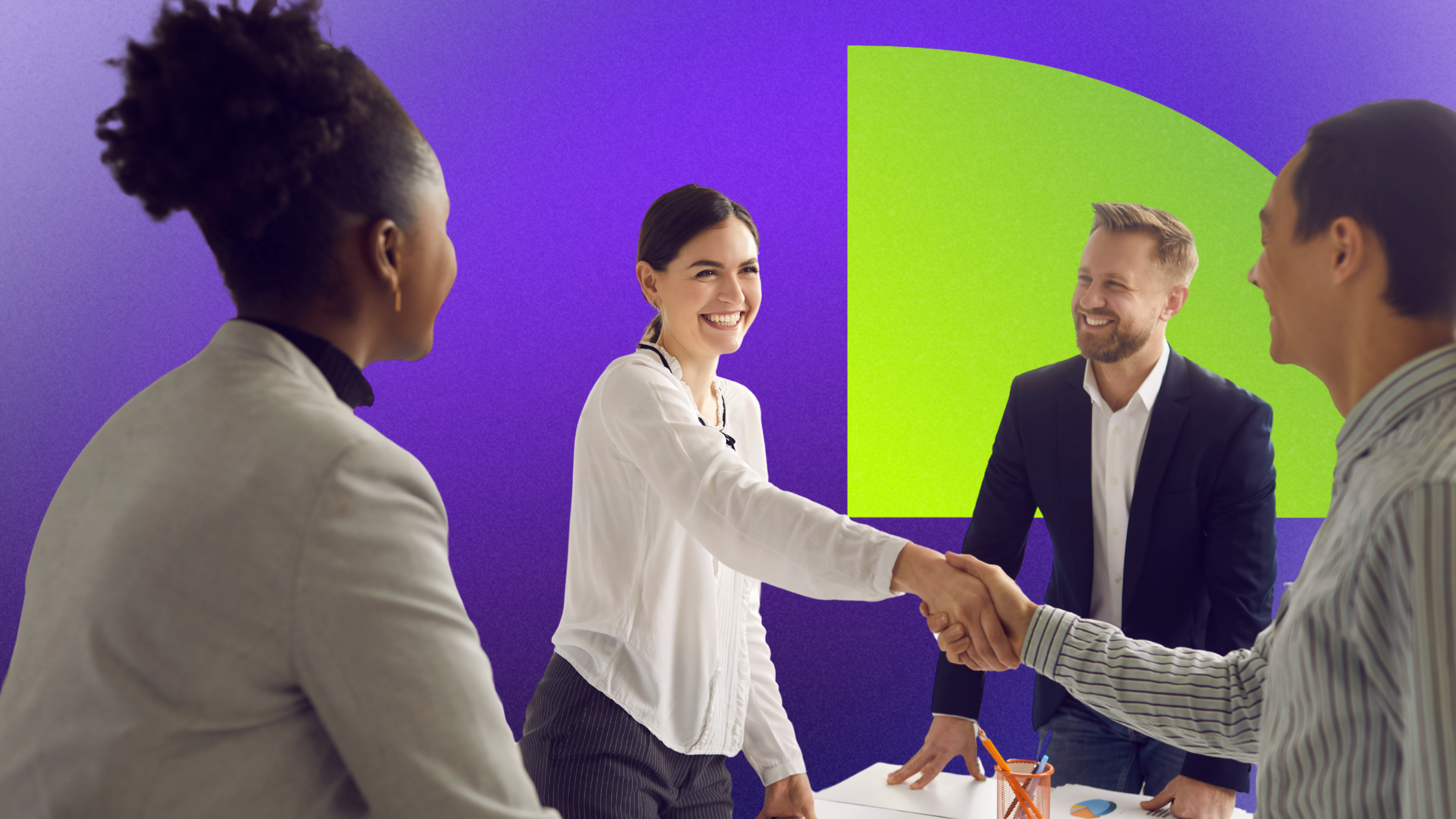 Business people shaking hands in a meeting room with a colorful background.
