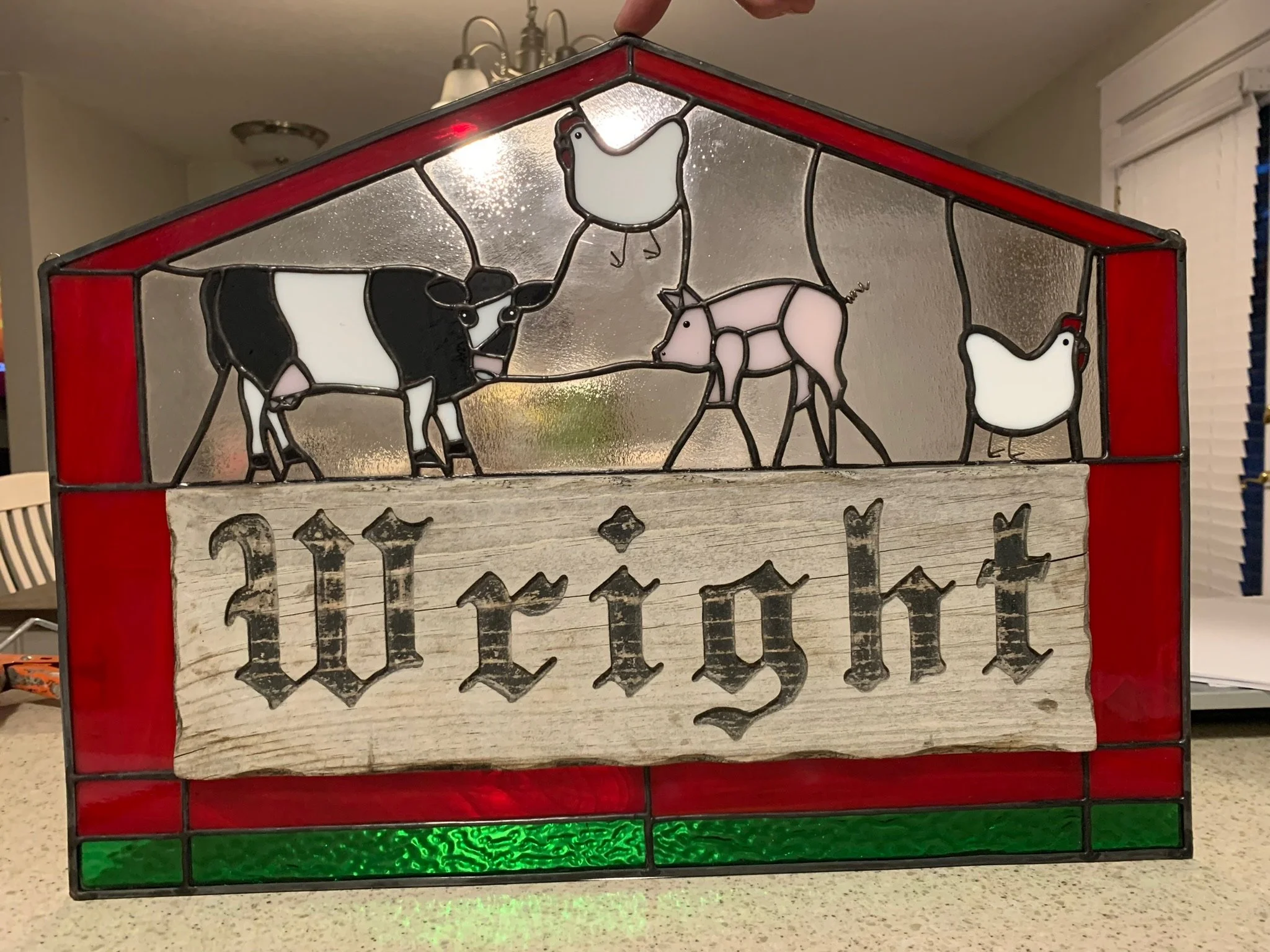 Stained glass decoration featuring a cow, a pig, and two chickens, with the words 'Farm Fresh' written below.
