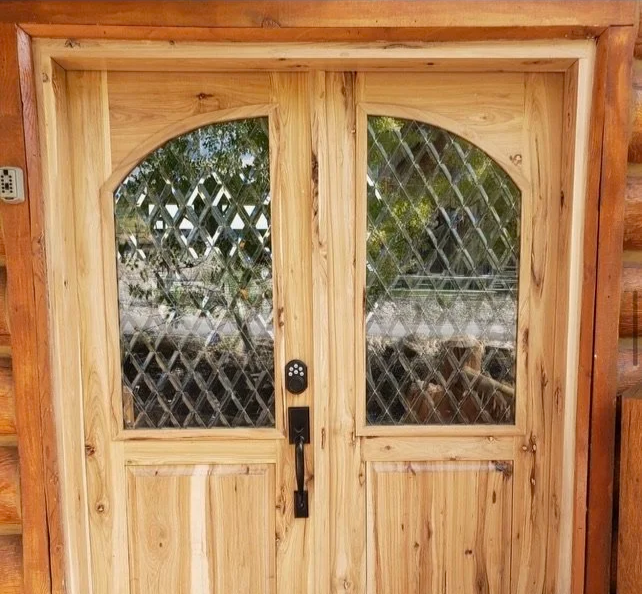 Wooden exterior door with diamond-patterned glass windows and a keypad lock.