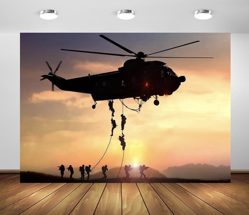 Silhouetted military personnel rappelling from a helicopter during sunset.