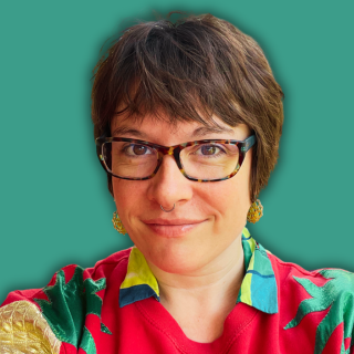 Photo of Hannah Desmond, tech-savvy VA, white person with brown hair and glasses in pink jumper.