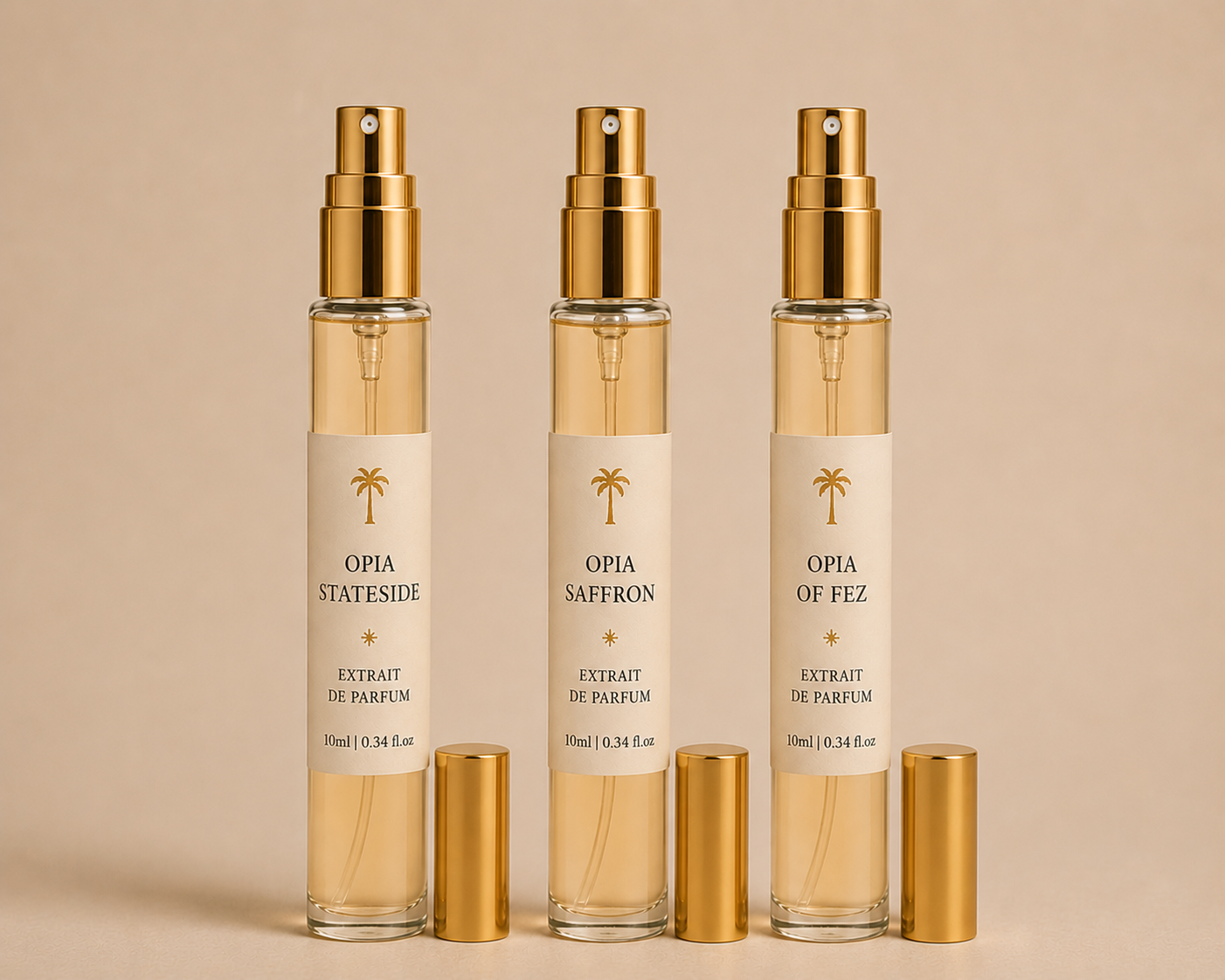 Three perfume spray bottles labeled Opia Stateside, Opia Saffron, and Opia of Fez, with gold caps and clear bodies showing the perfume inside, arranged in a row against a neutral background.