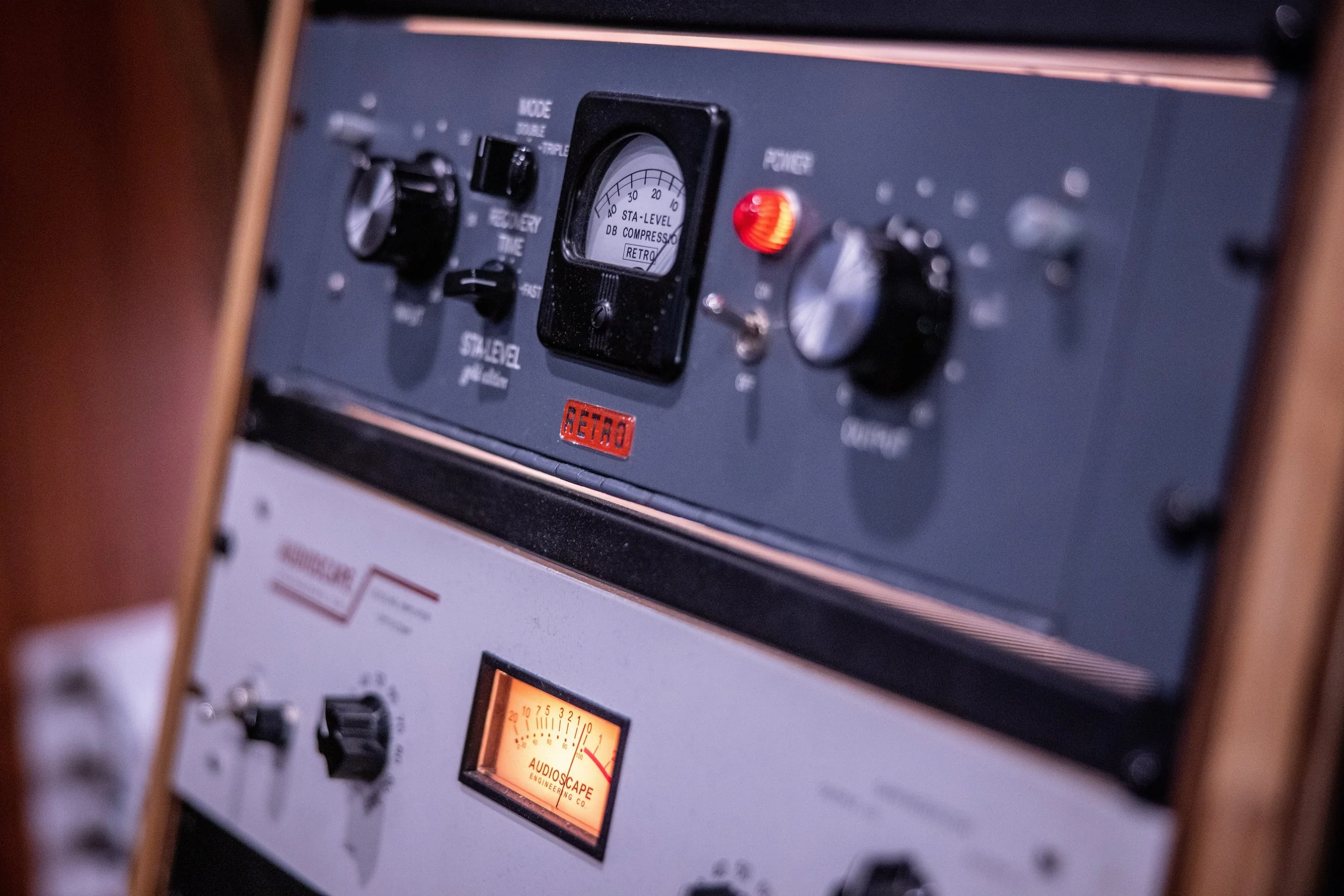 Close-up of vintage audio equipment with various dials and levels, featuring labels such as 'Sta-Level' and a 'LA-2A'