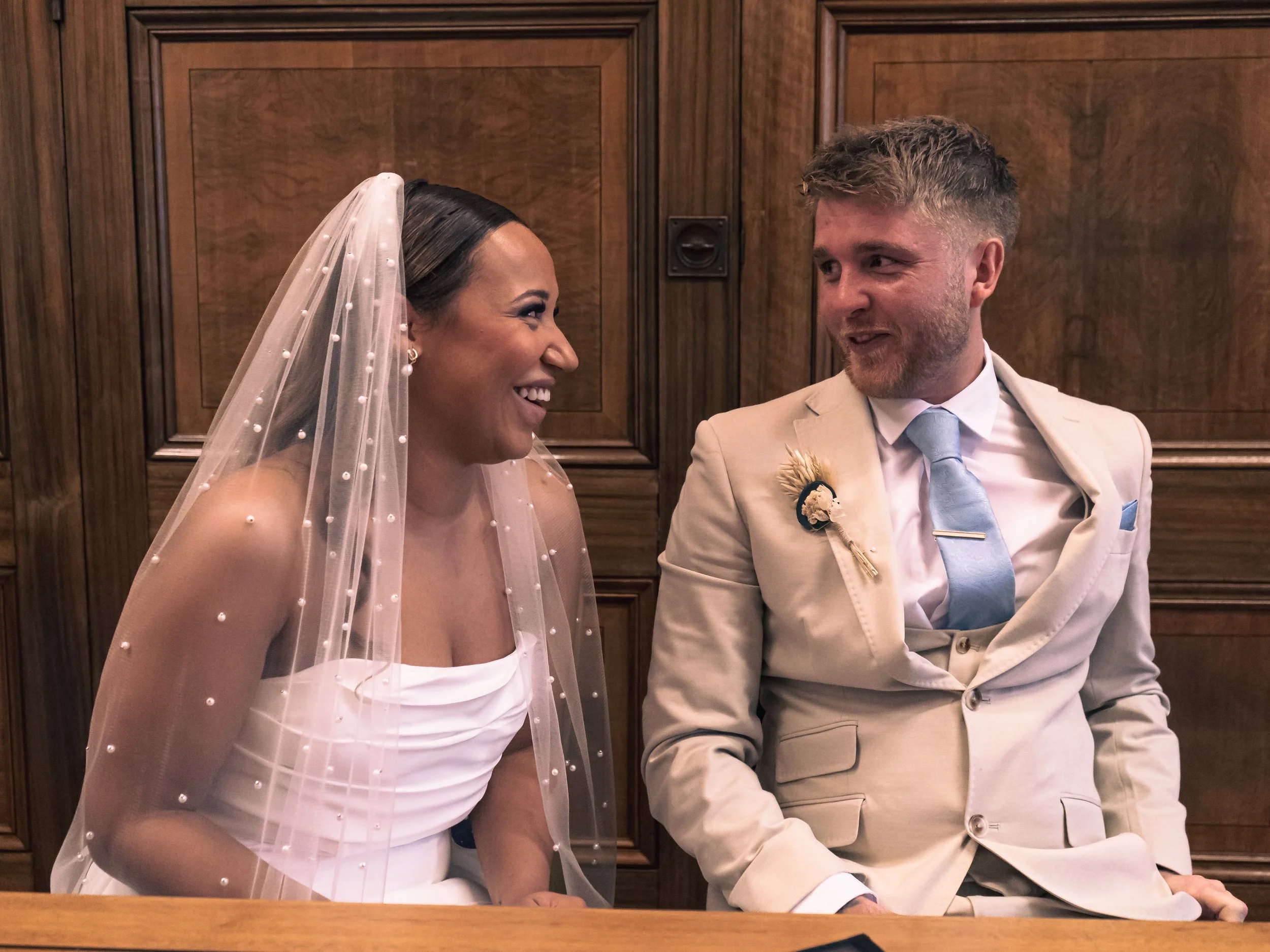 Bride and groom smiling at each other at their wedding ceremony