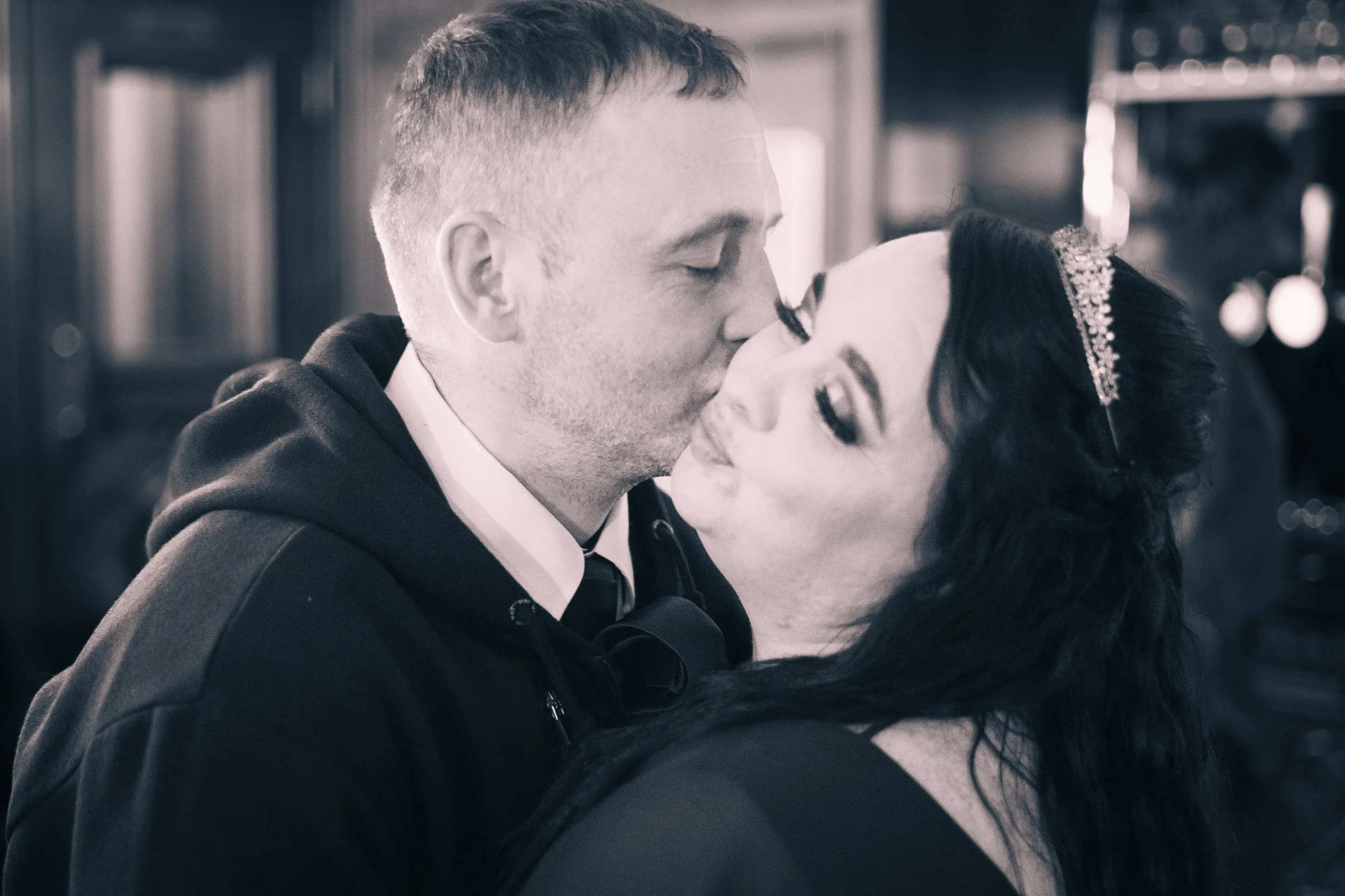 A couple sharing a kiss in a close embrace.