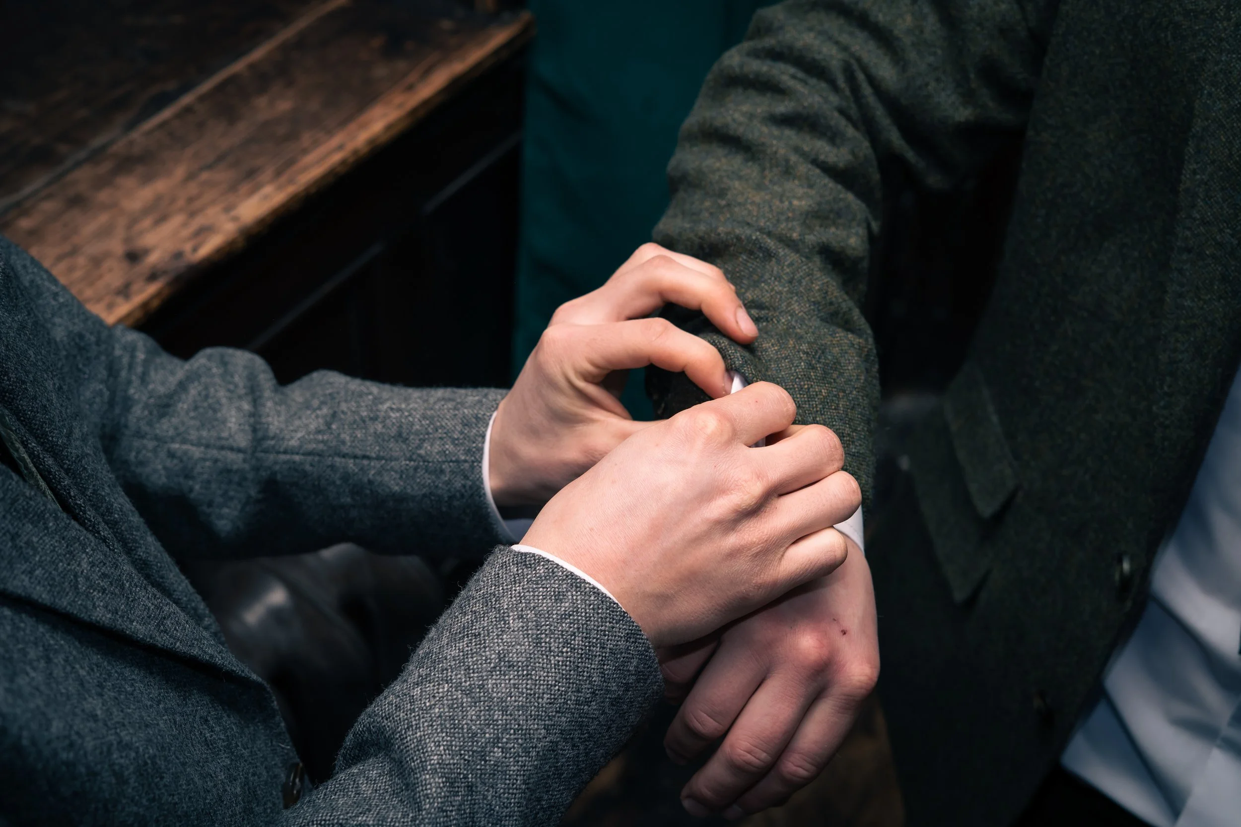 Two people shaking hands, with one person's hand gripping the other's arm in a firm handshake.