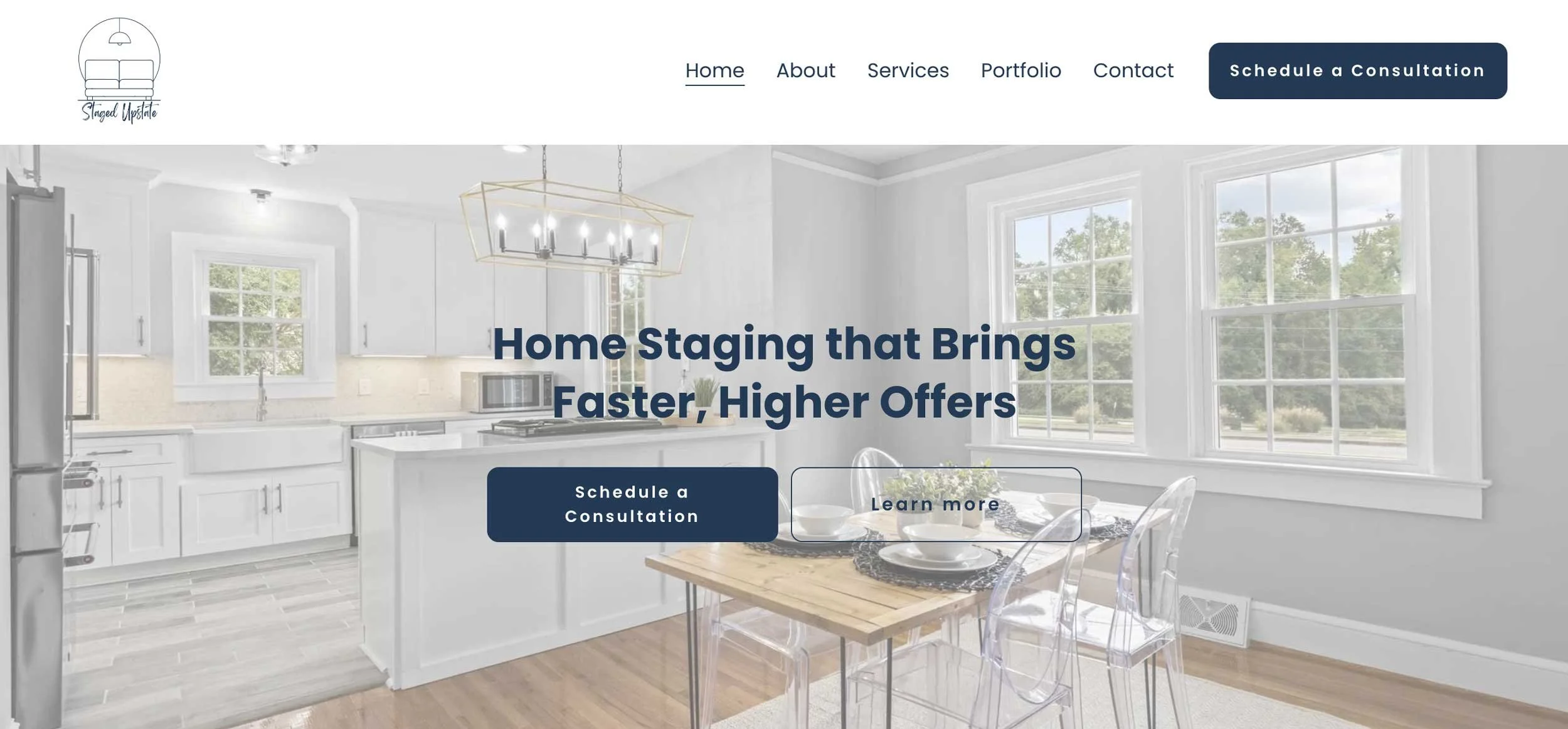 Home interior with large windows, white kitchen cabinets, a microwave, a dining table set with plates and glasses, and a chandelier