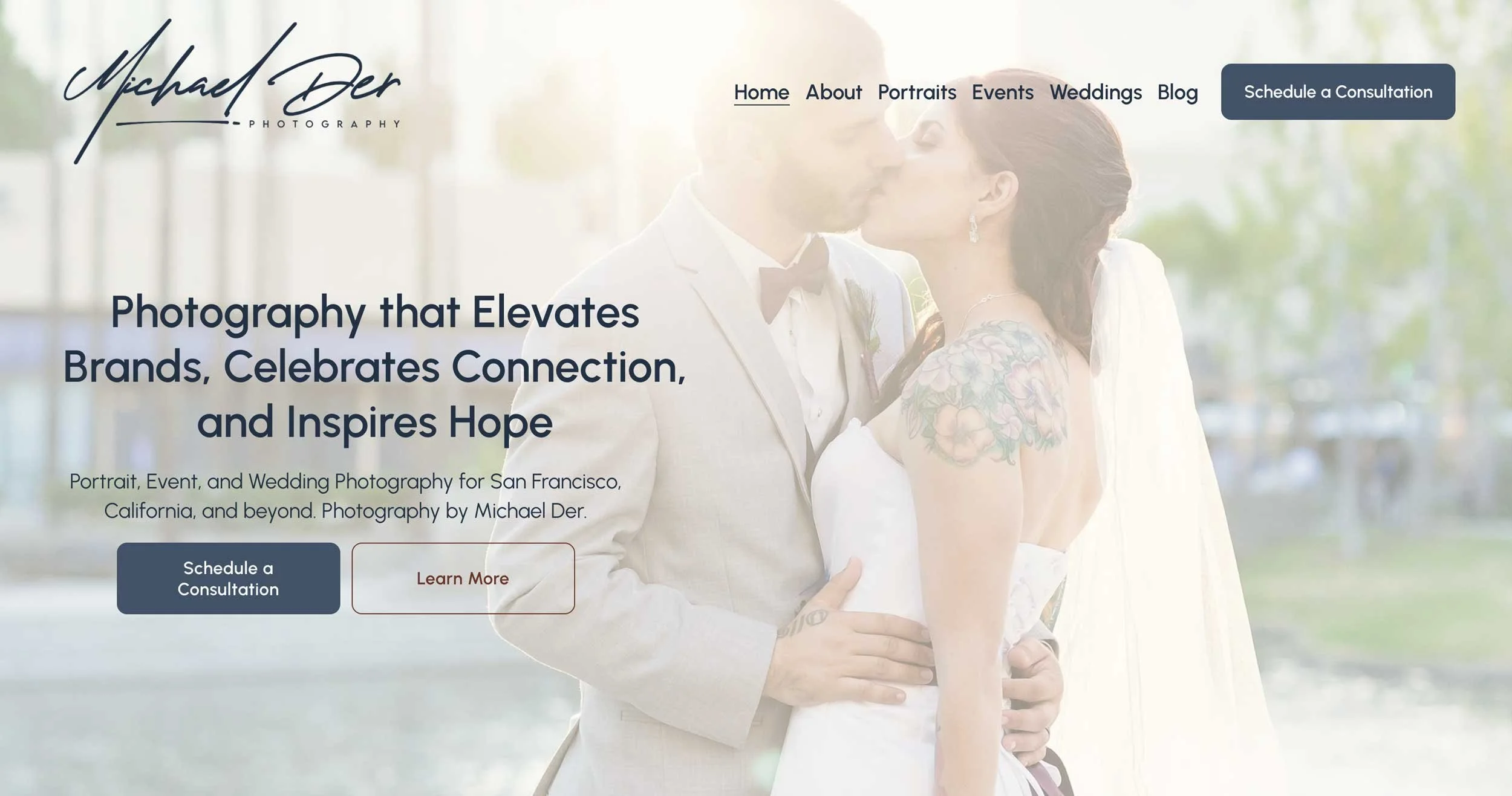 Website homepage of Michael Der Photography showing a couple, presumably newlyweds, sharing a kiss outdoors with trees in the blurred background.