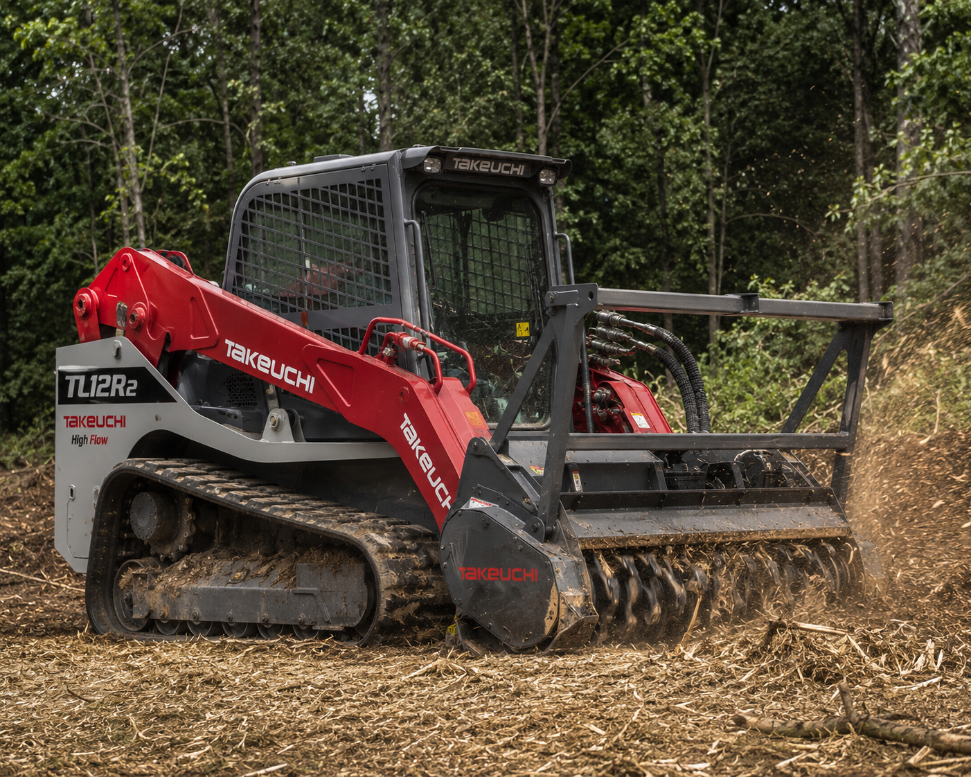 A red and black Takeuchi compact tracked hydraulic excavator working on a dirt clearing project in a forested area.