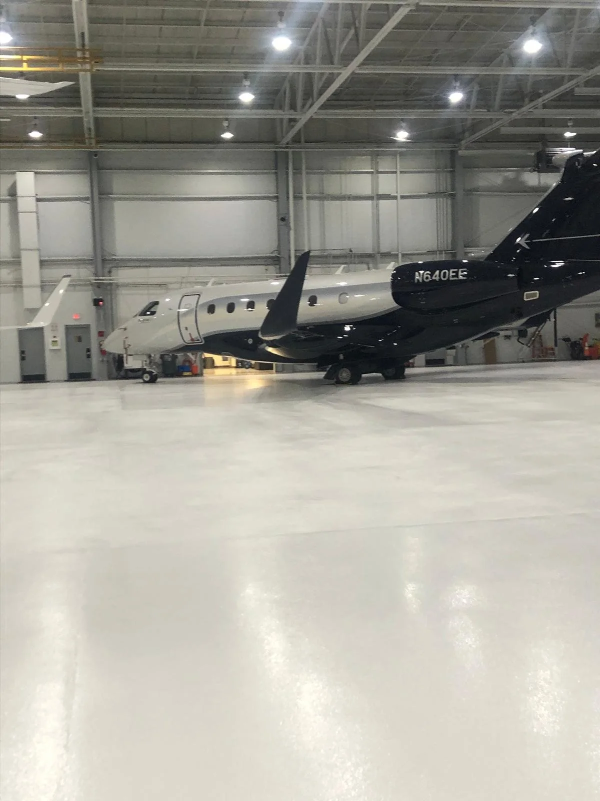 A white and blue private jet in an airplane hangar.