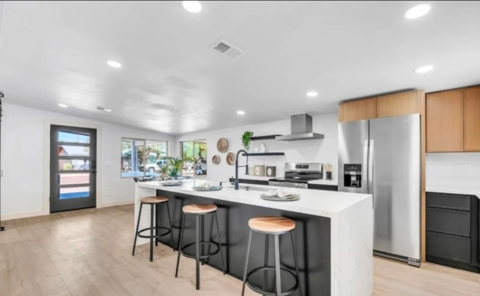 Arizona kitchen remodel featuring a large island, modern cabinetry, stainless steel appliances, open shelving, and updated finishes.