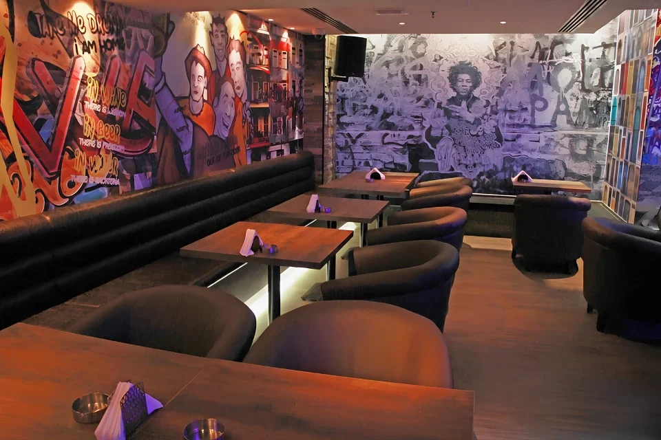 A lounge in Holiday Inn Al Barsha Dubai with upholstered chairs and graffiti on the walls
