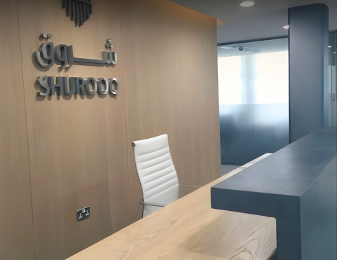 Office reception design for Shurooq in Sharjah featuring clean lines, wood paneling, and integrated branding elements