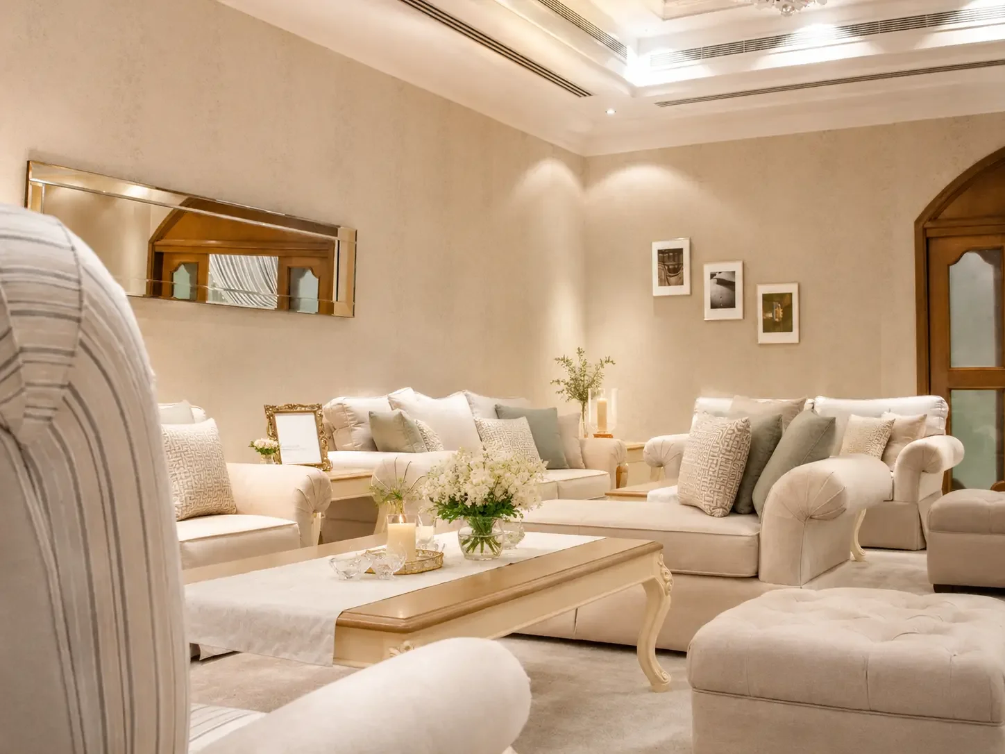 Elegant semi-classical living room in Sharjah with custom upholstered seating, soft neutral palette, and layered lighting.