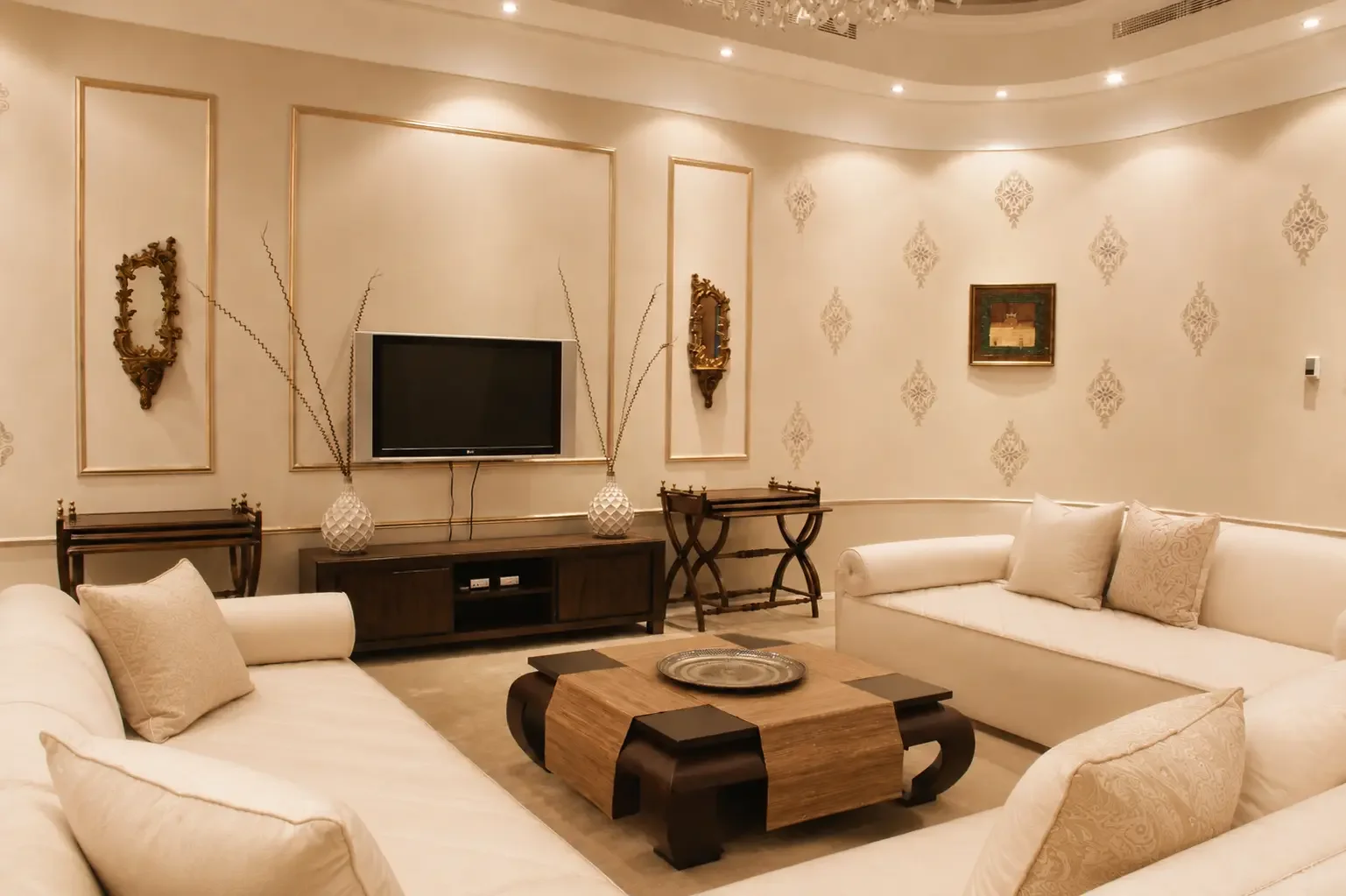 Semi-classical family lounge in a Sharjah villa featuring custom furniture, neutral upholstery, and elegant wall detailing.